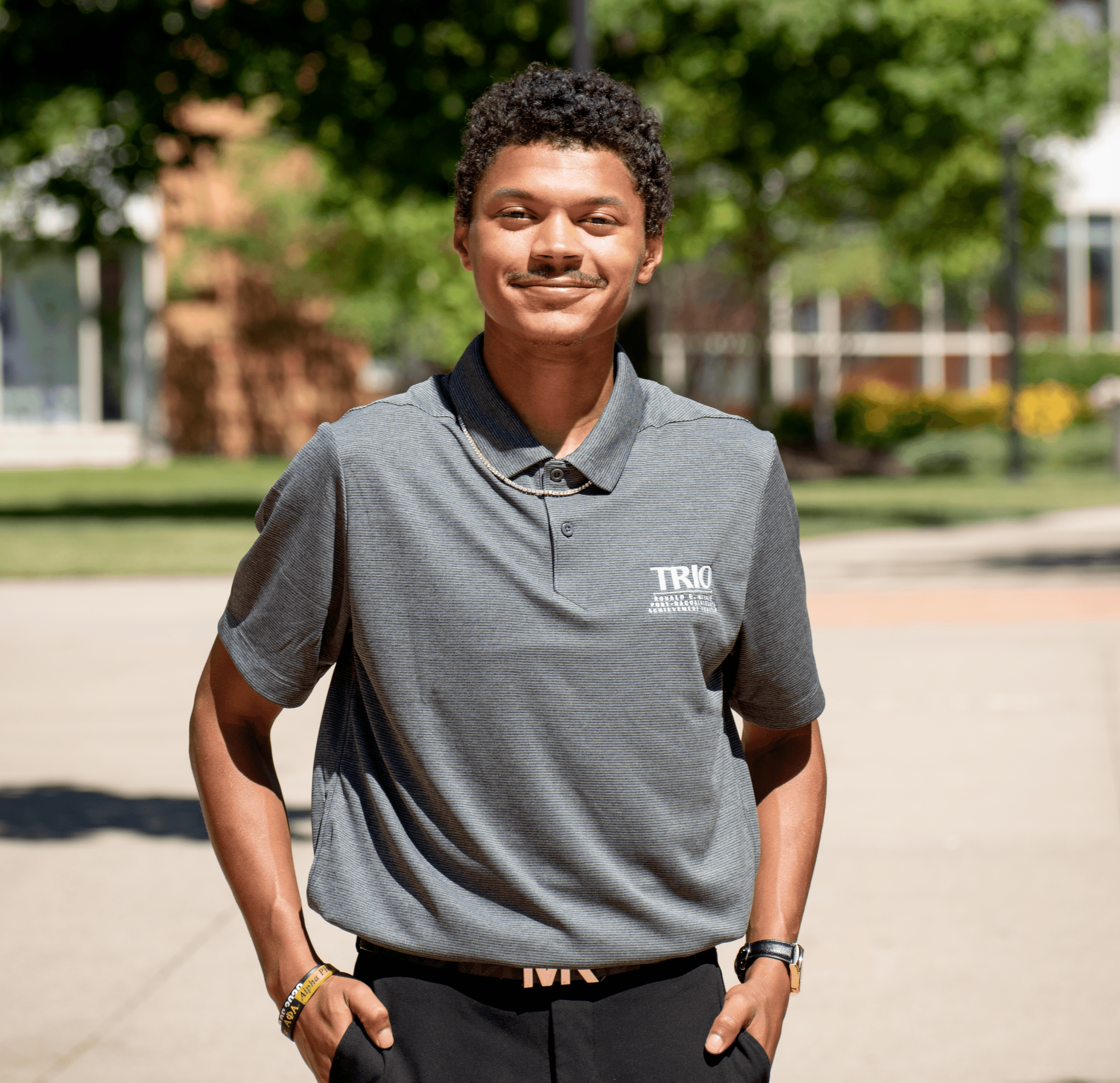 Jayden Donald standing with hands in his pocket wearing a gray shirt and dark pants.