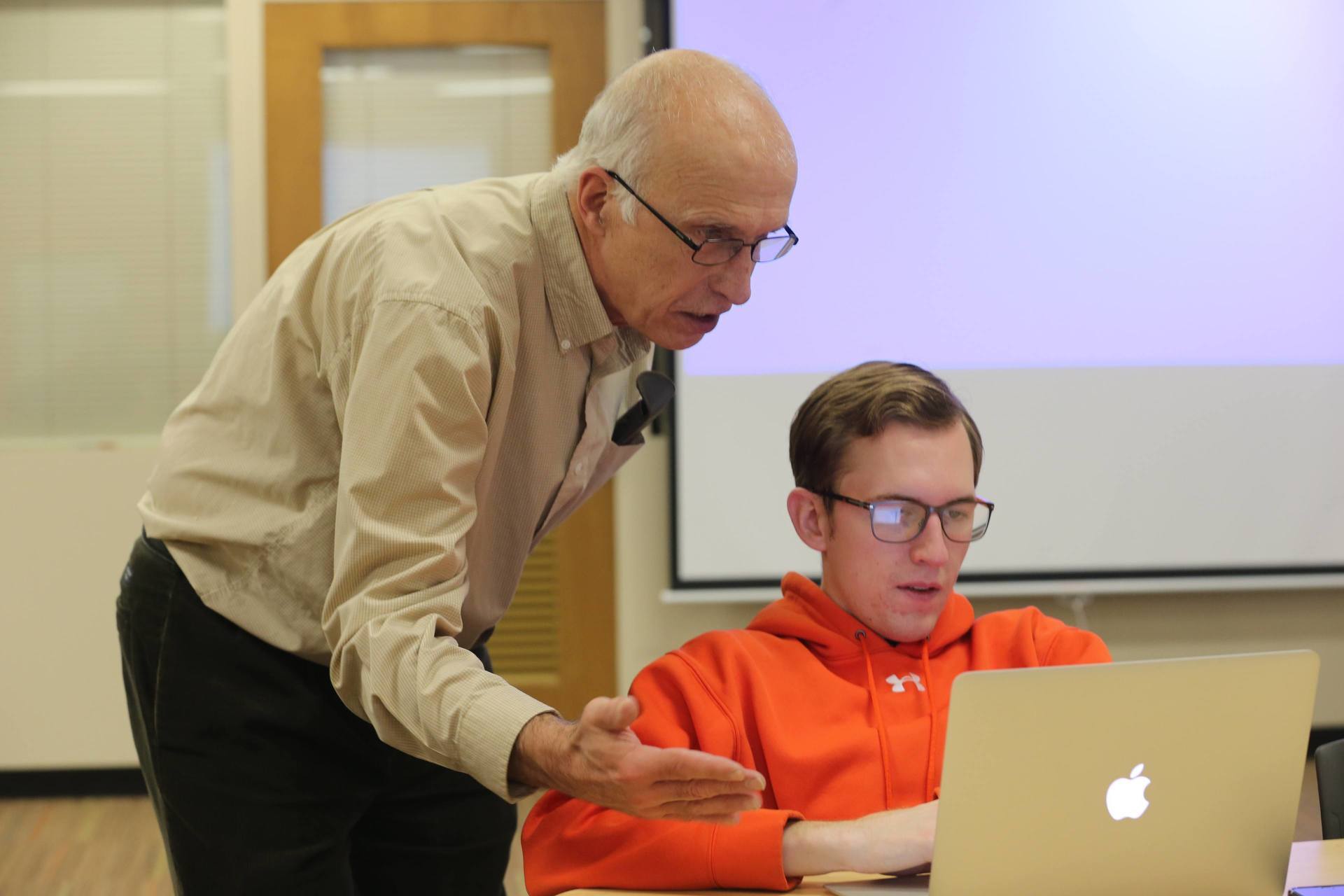 Professor with Data Science student looking at laptop