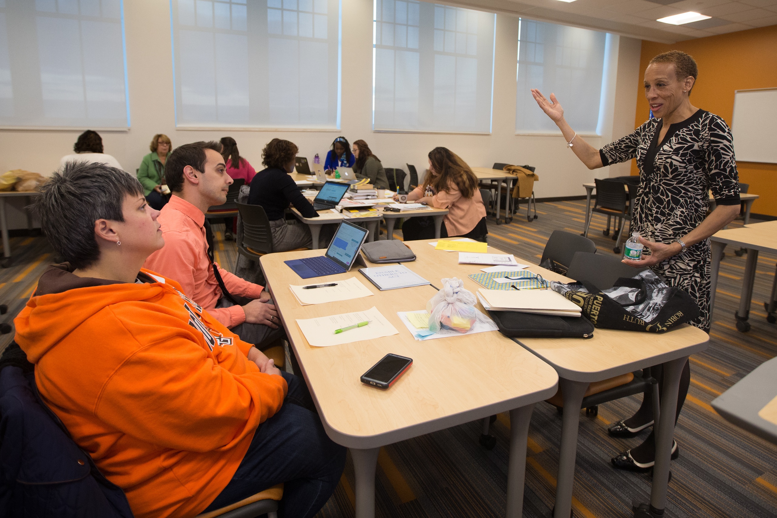 Educational leadership professor talks to two students 