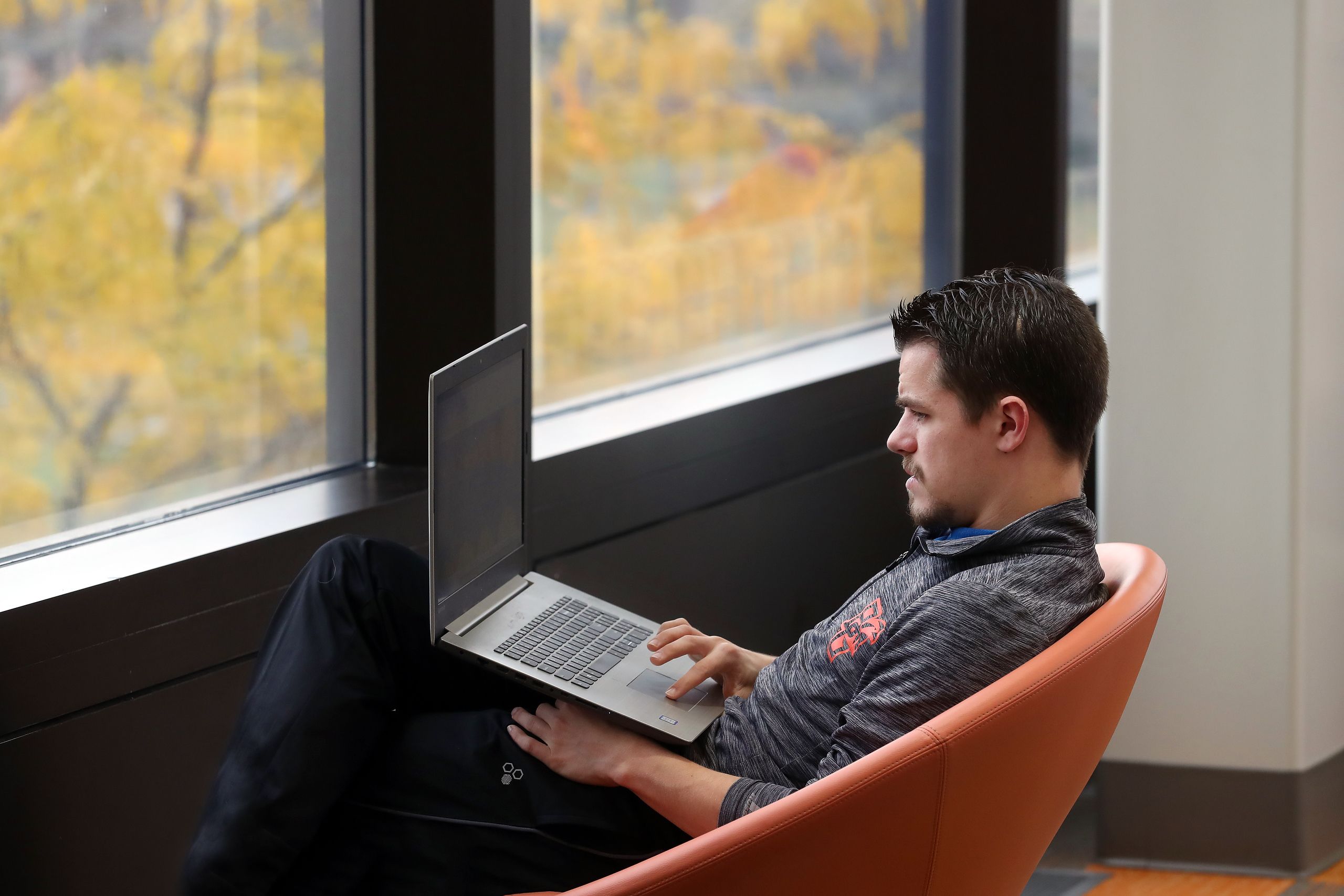 A BGSU MTM Engineering Technology student studies on a laptop while working, advancing their career and future job opportunities.