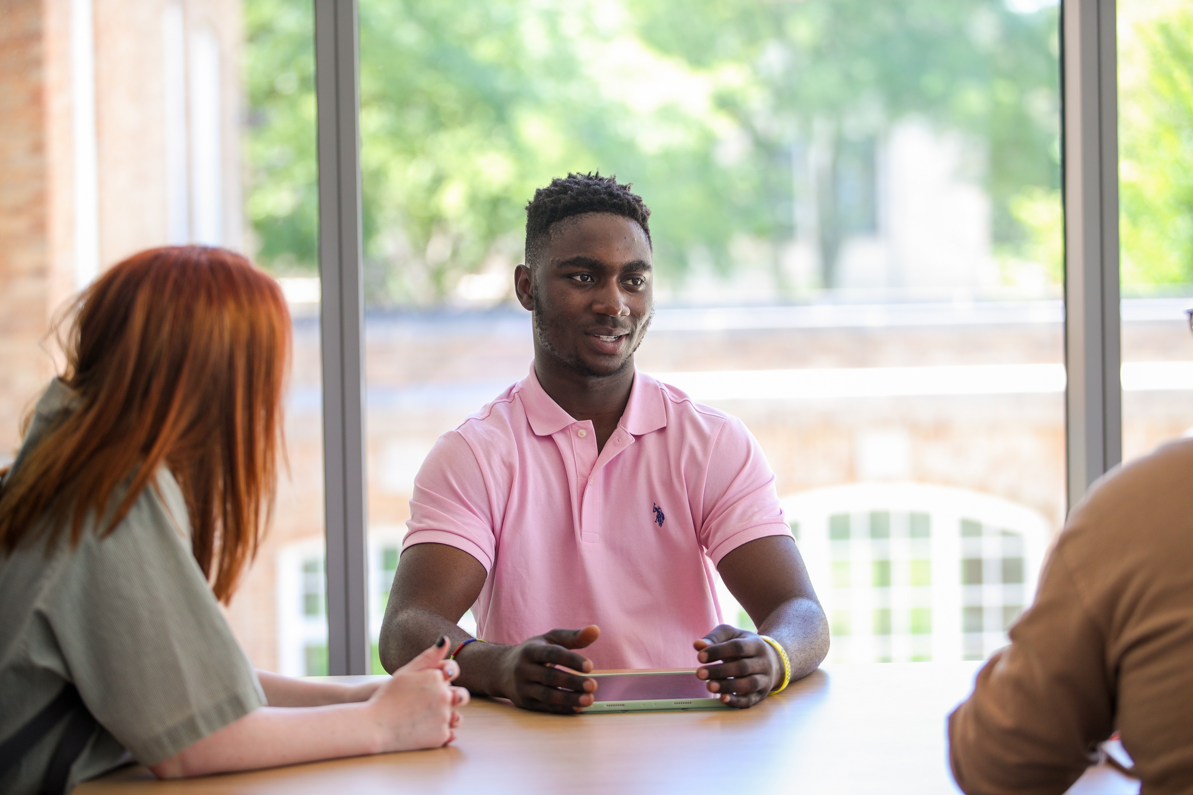 Three business students work together at a classroom table.