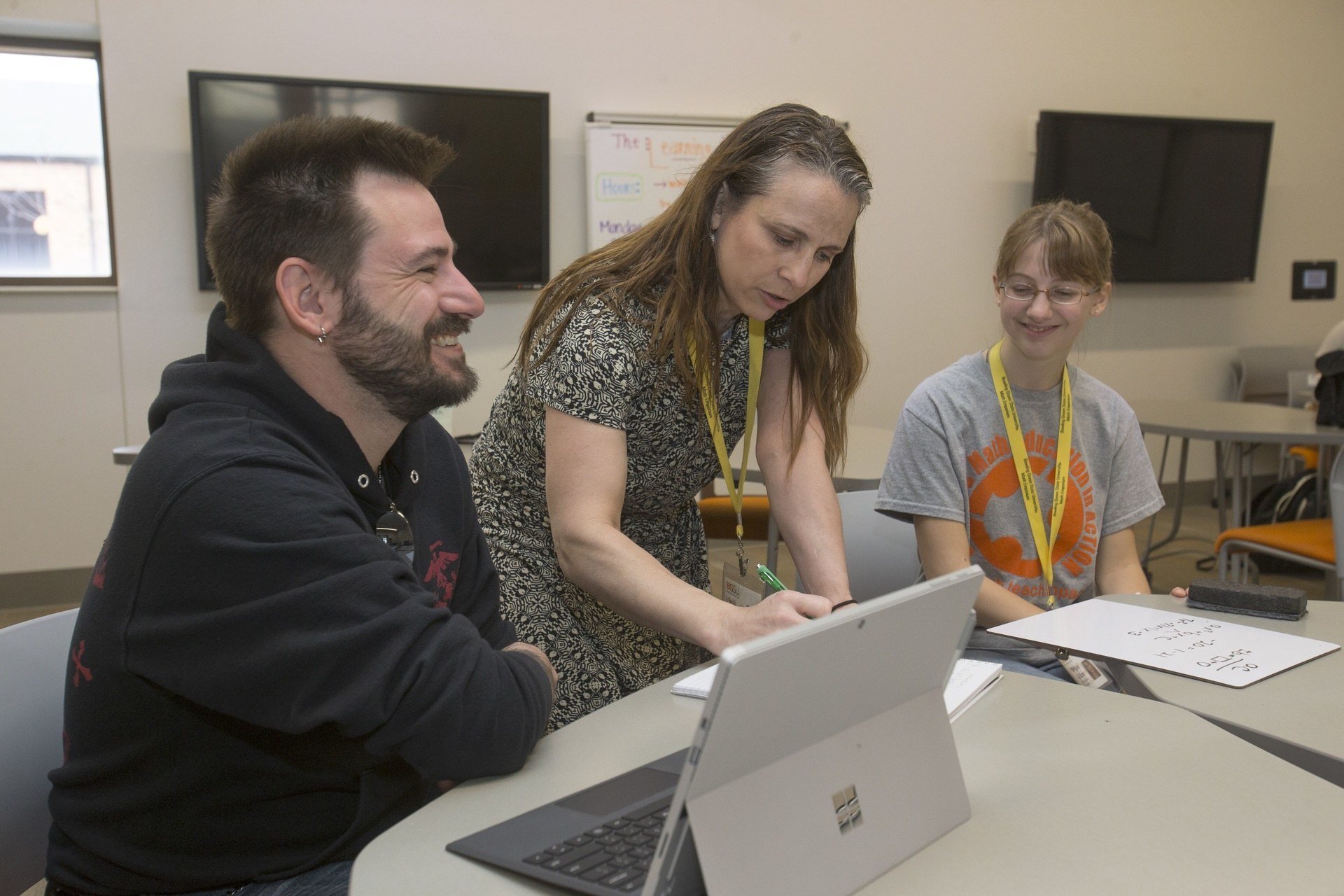 Professor is showing two students how to solve a math problem