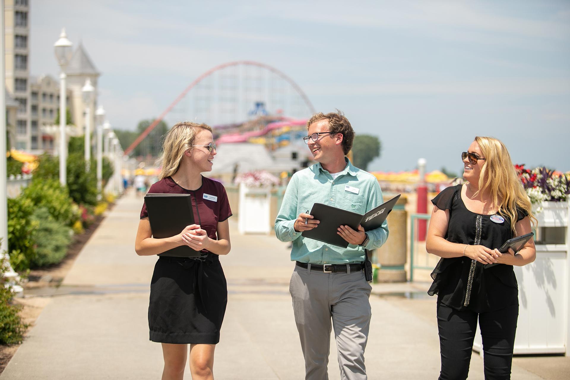 BGSU resort and attraction management students walk through the Cedar Point resort and theme park on a sunny day.