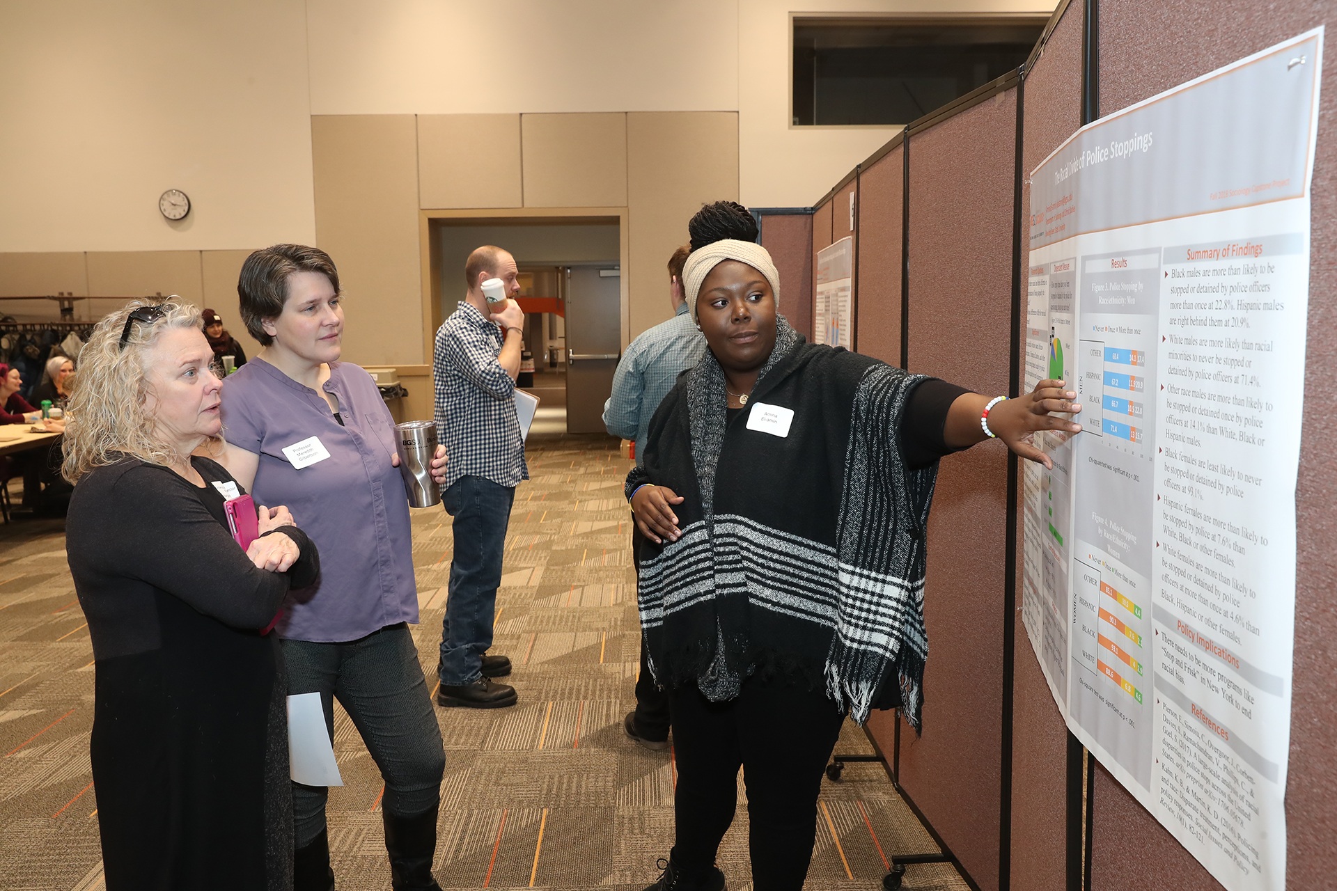 Dr. Margaret Weinberger (left) director of Undergraduate Studies in sociology with students during a research poster review.