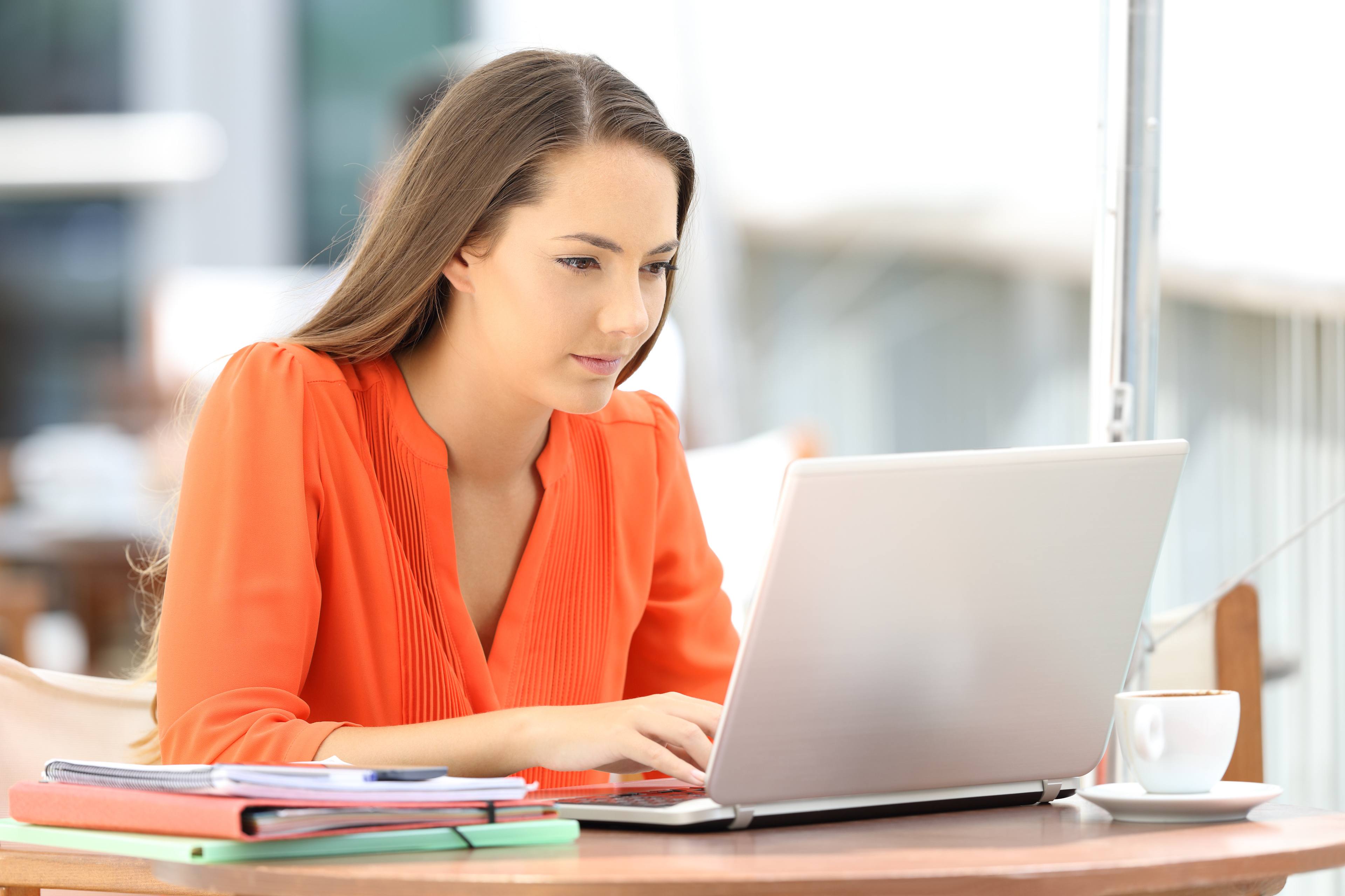 College student using a laptop in a coffee shop