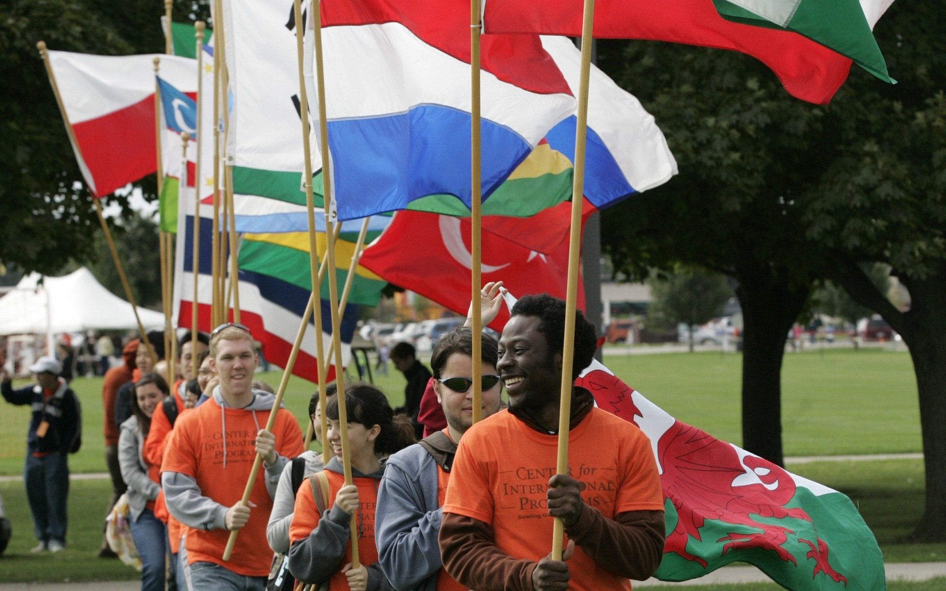 BGSU students walk through campus holding international flags.