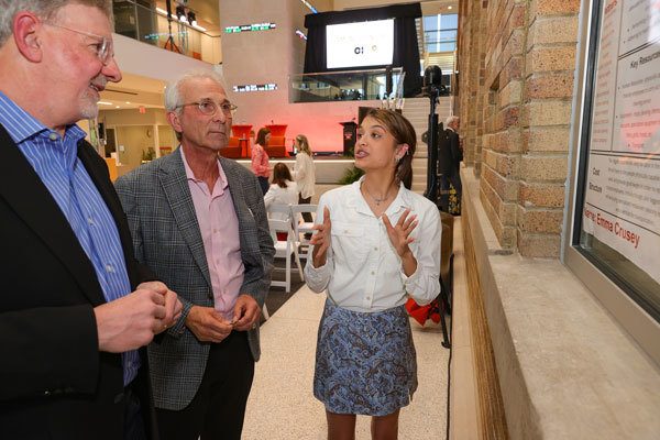 Emma Crusey explains her posterboard and business idea to investors at the 2023 Hatch in the Maurer Center on BGSU's campus.