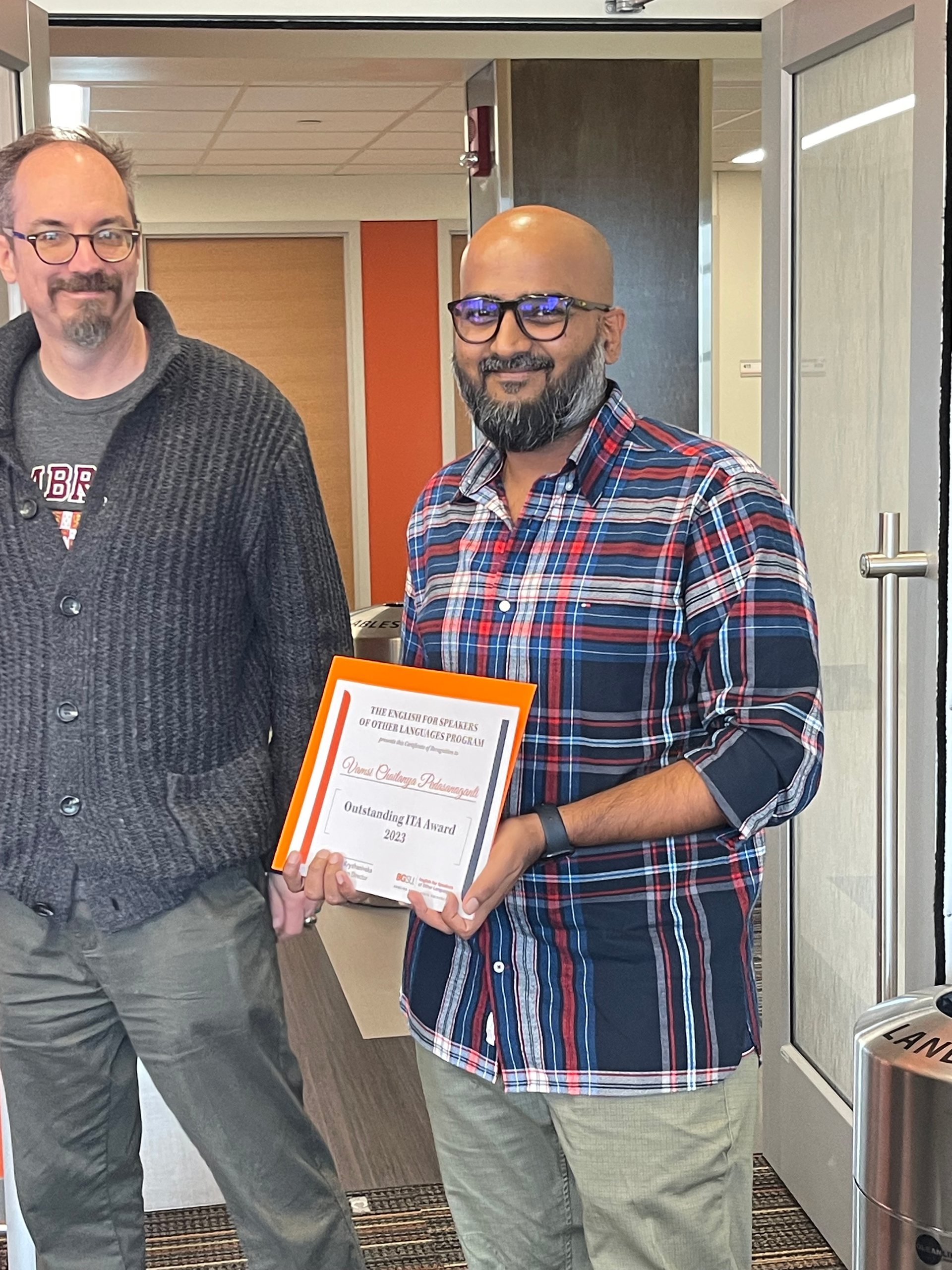 Vamsi with Outstanding ITA award certificate next to Dr. Joshua Atkinson 