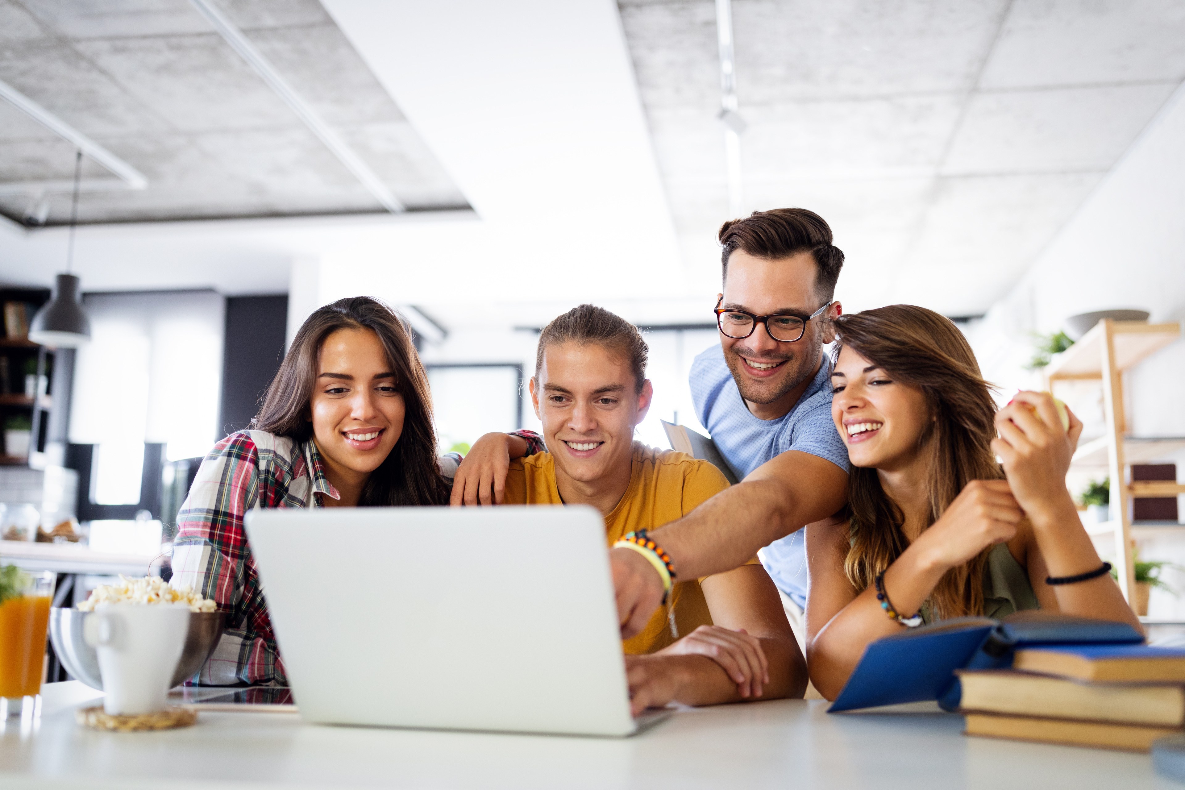 Multiracial young people enjoying group study at table.