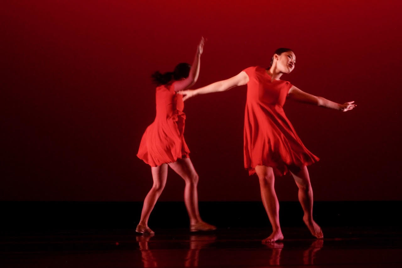 Two dancers in red against a red background