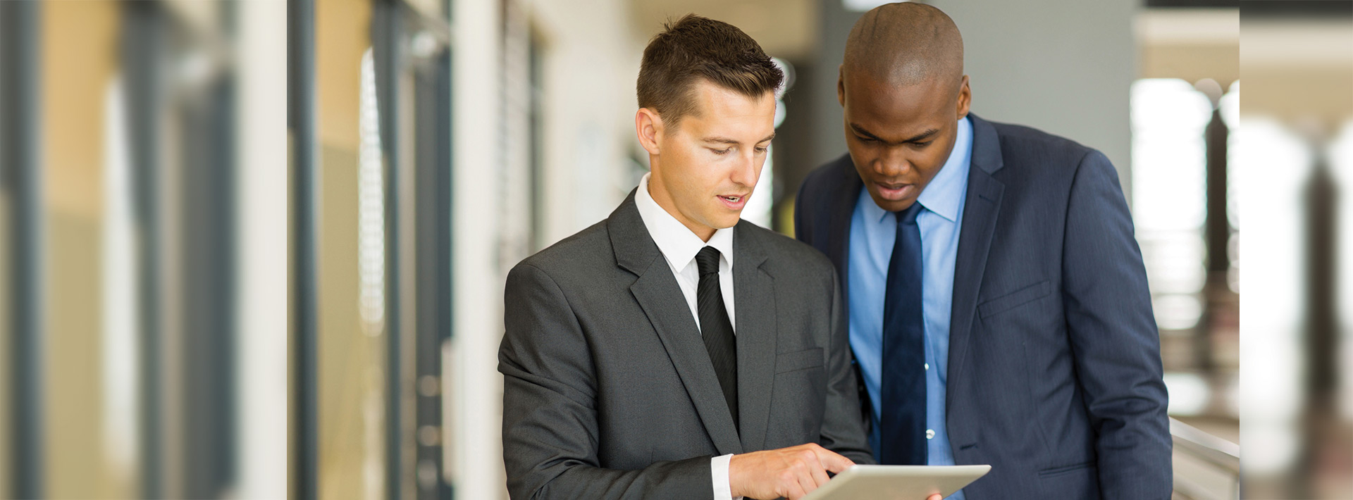 two businessmen using tablet computer