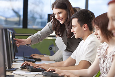 Teacher-using-computer-with-student