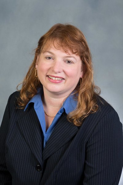 Professional headshot of Kim Fleshman wearing a blue suit