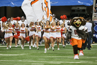 The BGSU Falcon Cheerleaders lead the football team onto the field for the start of the 2015 Marathon Mid-American Conference Championship Game at Ford Field in Detroit, Mich.