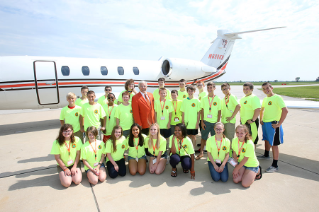 Campers at Falcon Millionaires joined J. Robert Sebo '58, ’13 (Hon.) center, former chair of BGSU Board of Trustees and retired senior vice president for Paychex Inc., on a tour of his jet. BGSU hosts a one-week financial camp, Falcon Millionaires, each summer in June.
