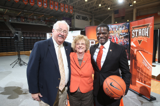 Former Board of Trustees Chair Francis C. (Fran) Voll and President Mary Ellen Mazey welcome new head men's basketball coach Michael Huger '94.