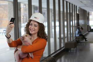 Alumni Laureate Scholar and construction management major Amey Hewitt '15 raised money for a service project when people donated to be able to take pictures with her miniature pig.
