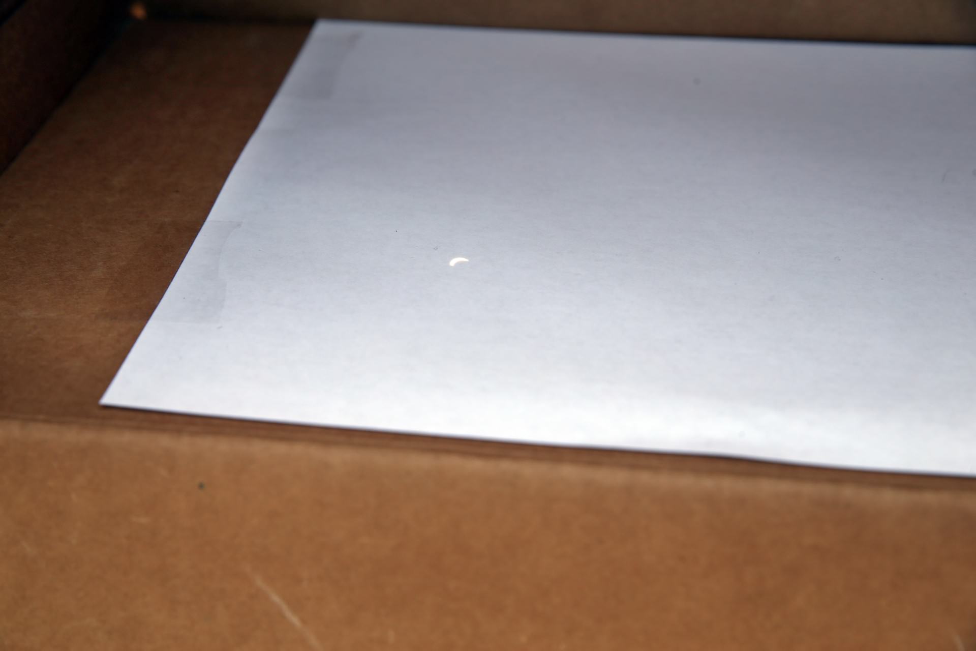 Solar eclipse cresent shining on white paper