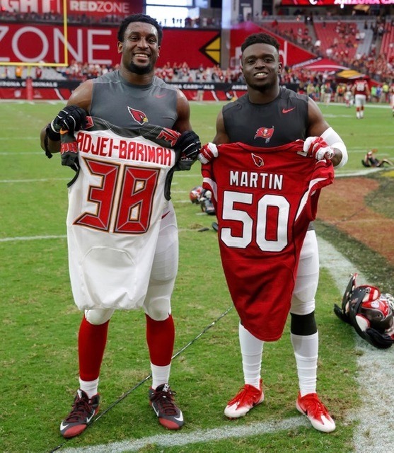 Gabe Martin  Jude Adjei-Barimah holding up their old football jerseys