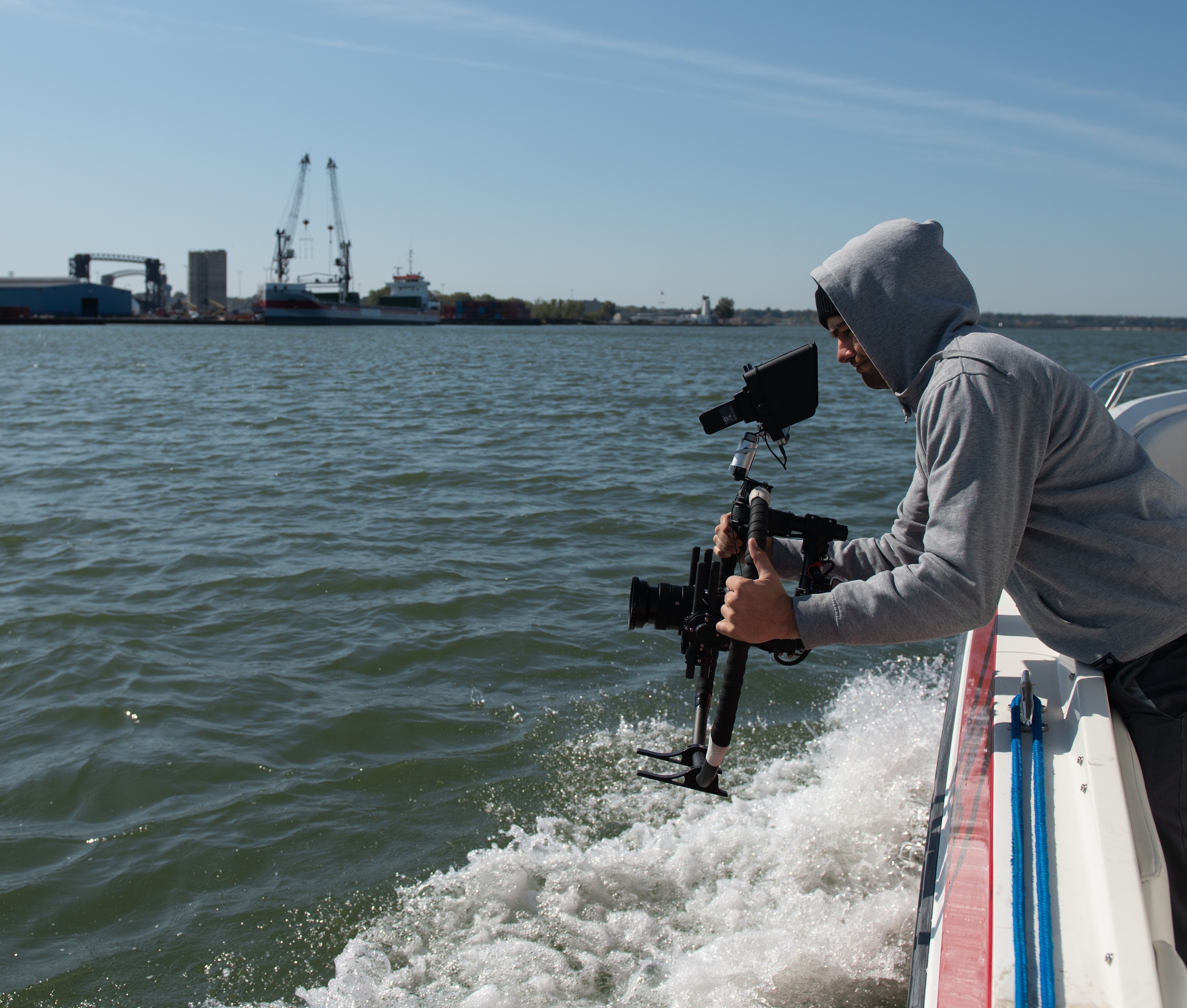 Chad Butler films the Cuyahoga River shoreline for a redevelopment project.
