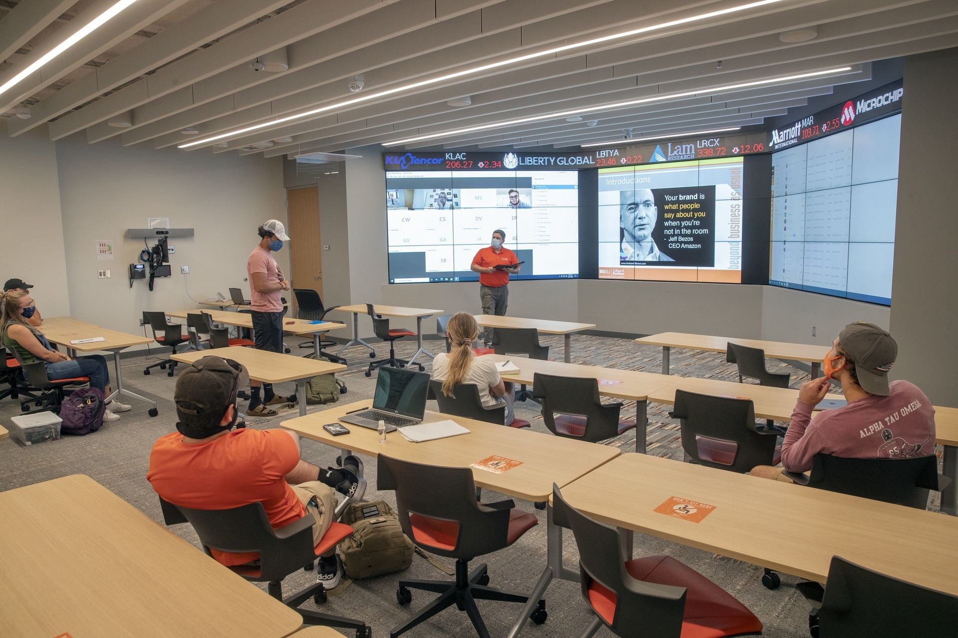 Students and professor in classroom in front of big monitors