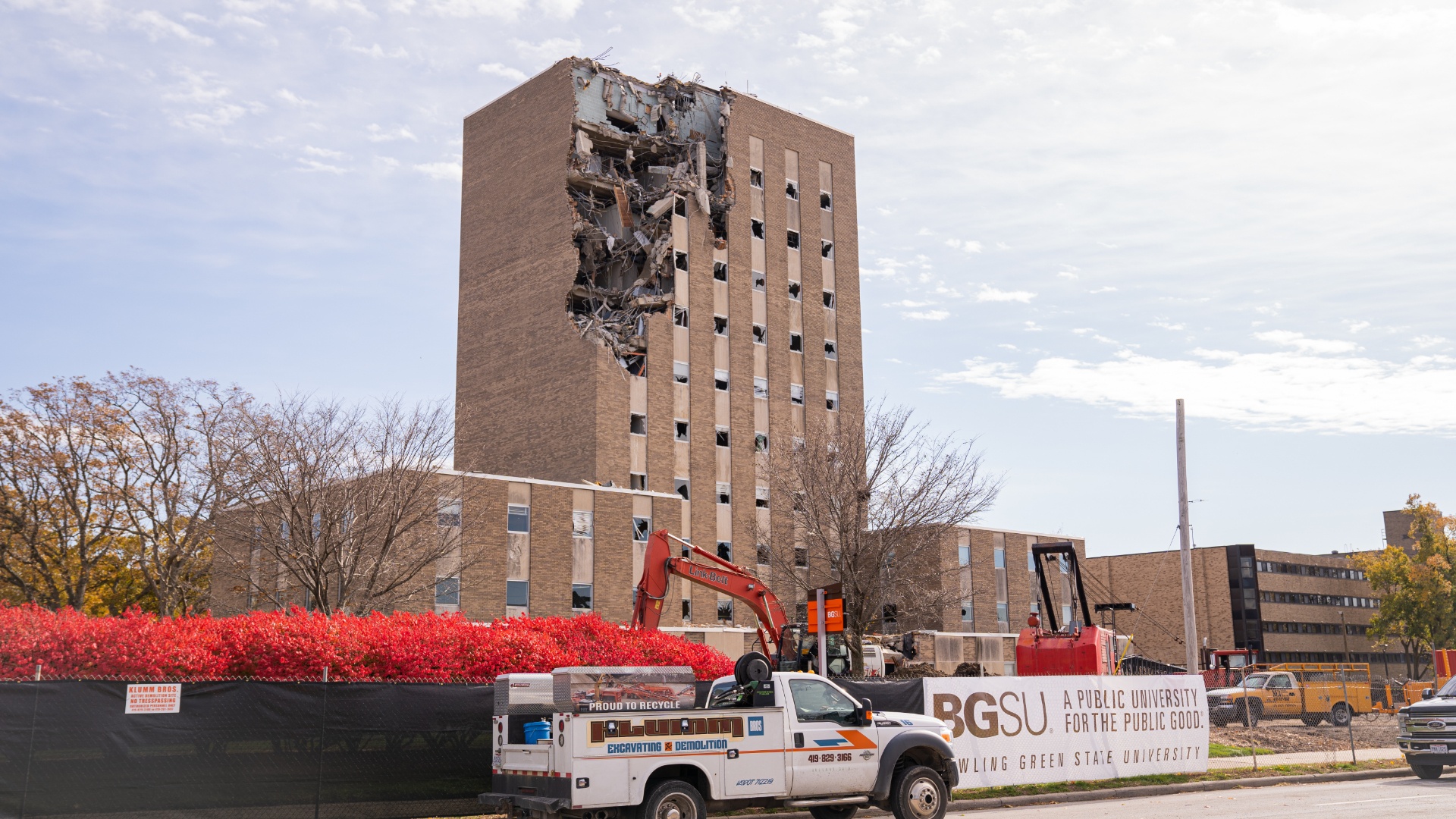 administration building missing the front wall on the top few floors with construction site in front of the building