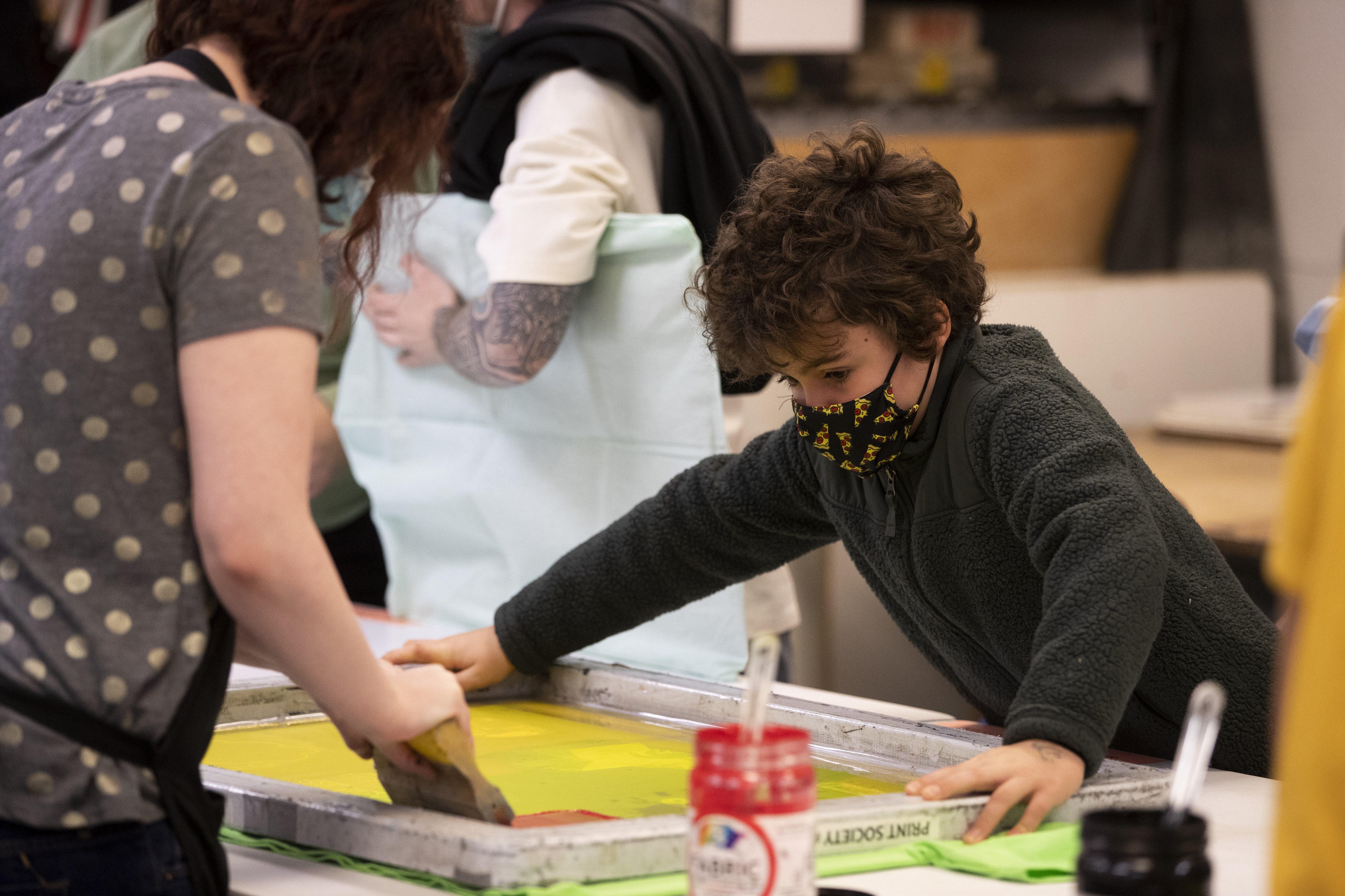 A student and kid screen print a design