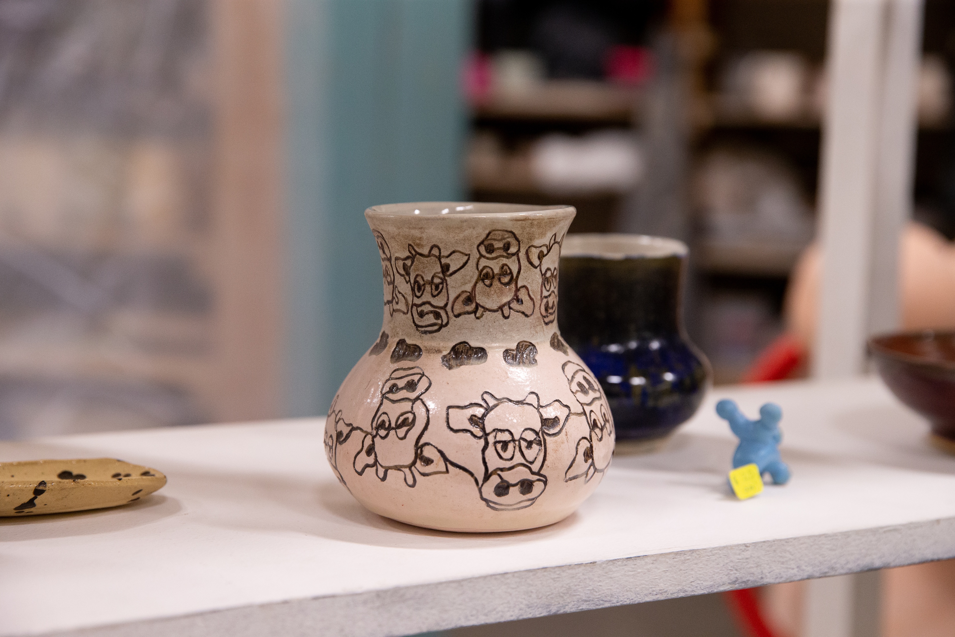 A vase with artwork depicting cows on it