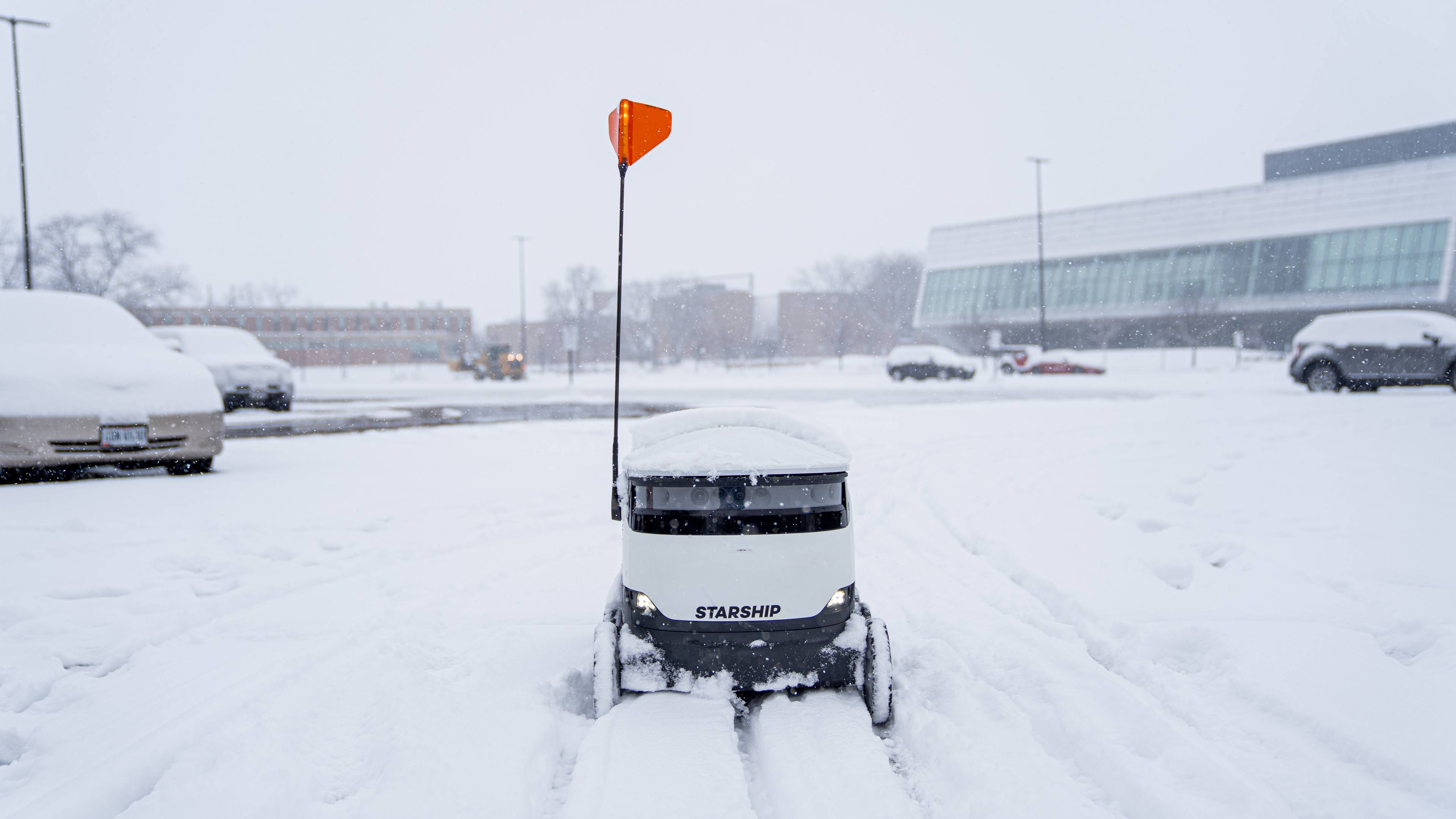 The Starship show must go on! Delivery robots work through the elements, plowing through a snowy lot near the Wolfe Center. 