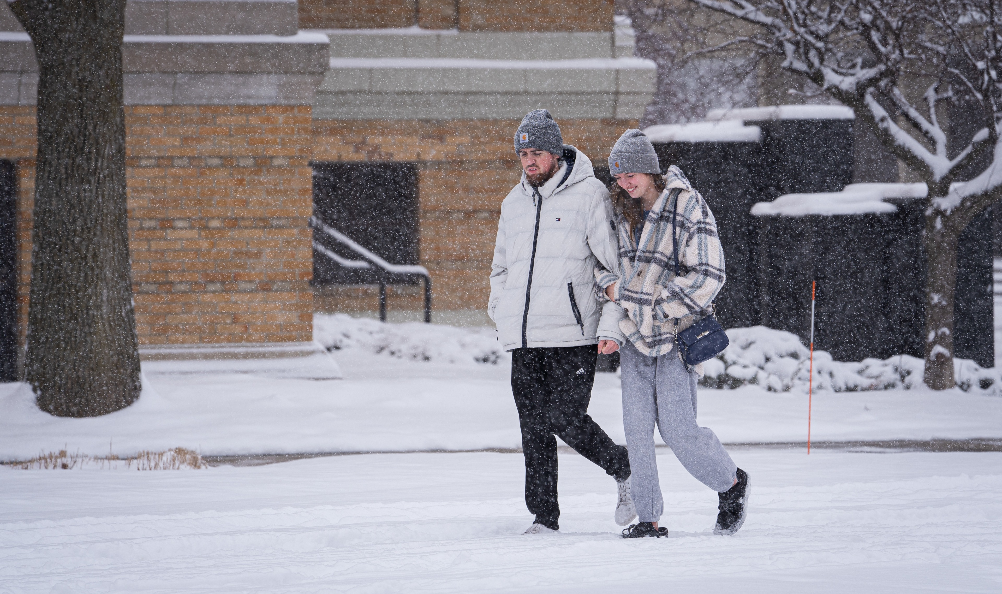 Students bundle up to walk through the snow on campus. 