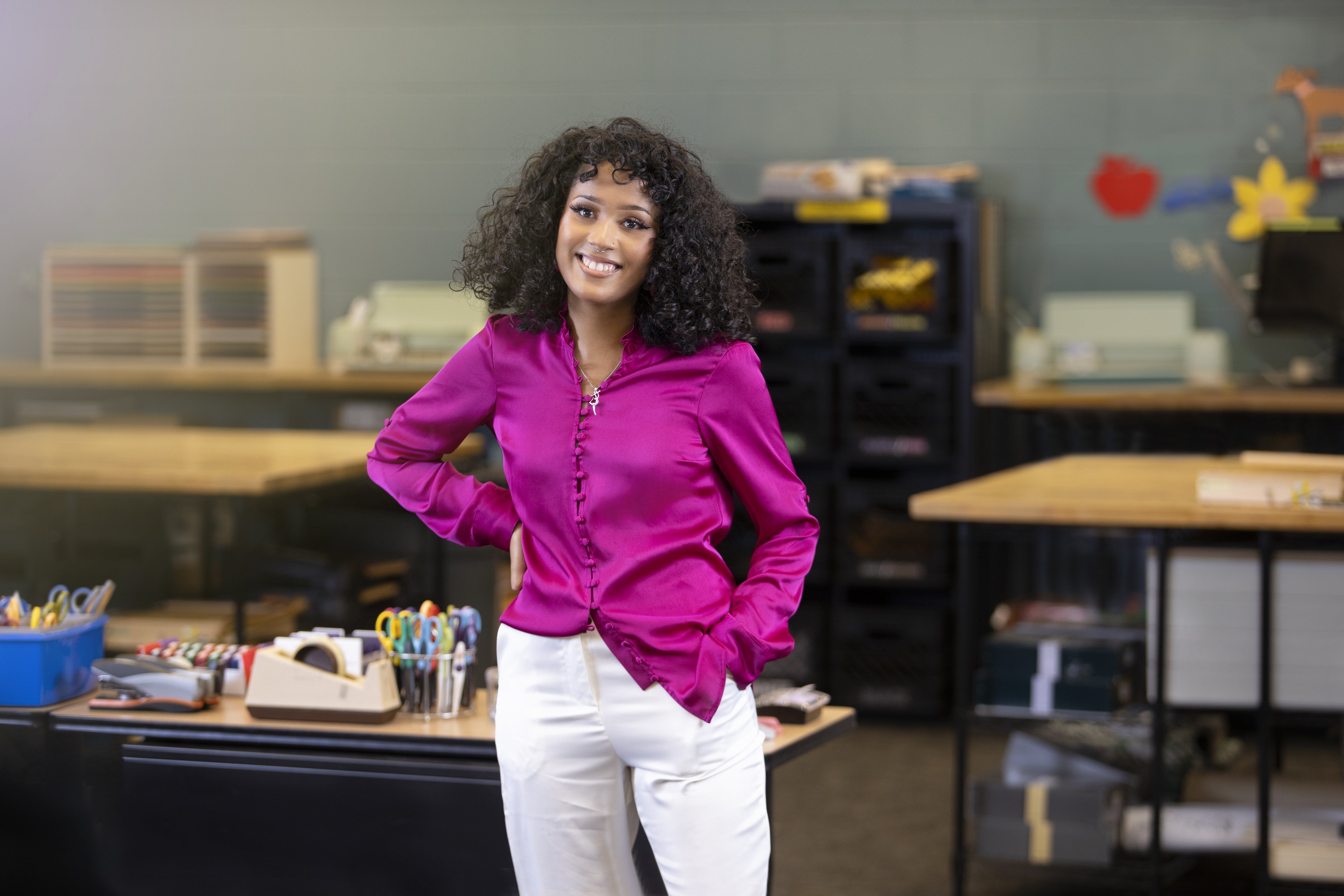 Student, in classroom, with pink blouse smiling