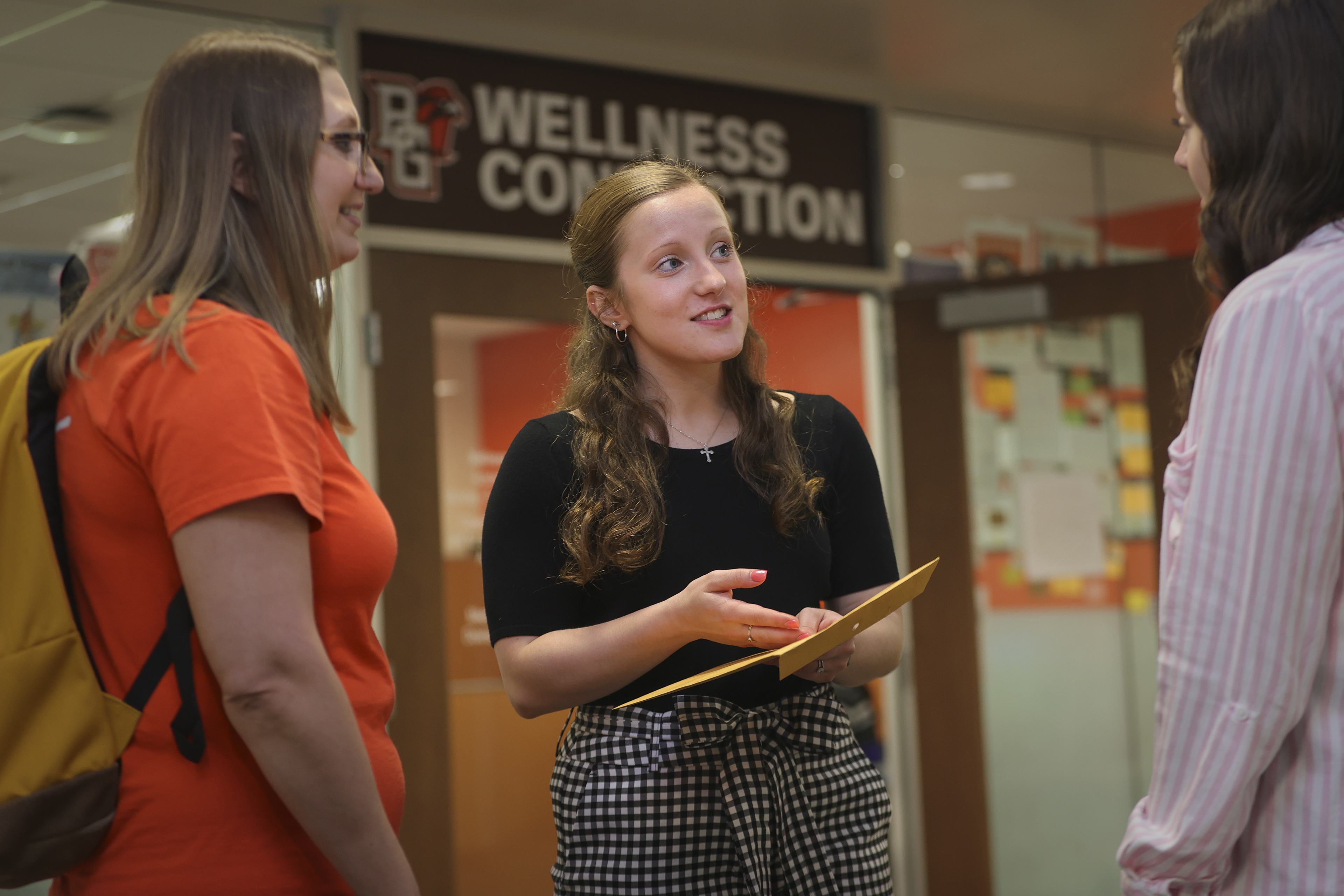 Three students talking indoors at BGSU