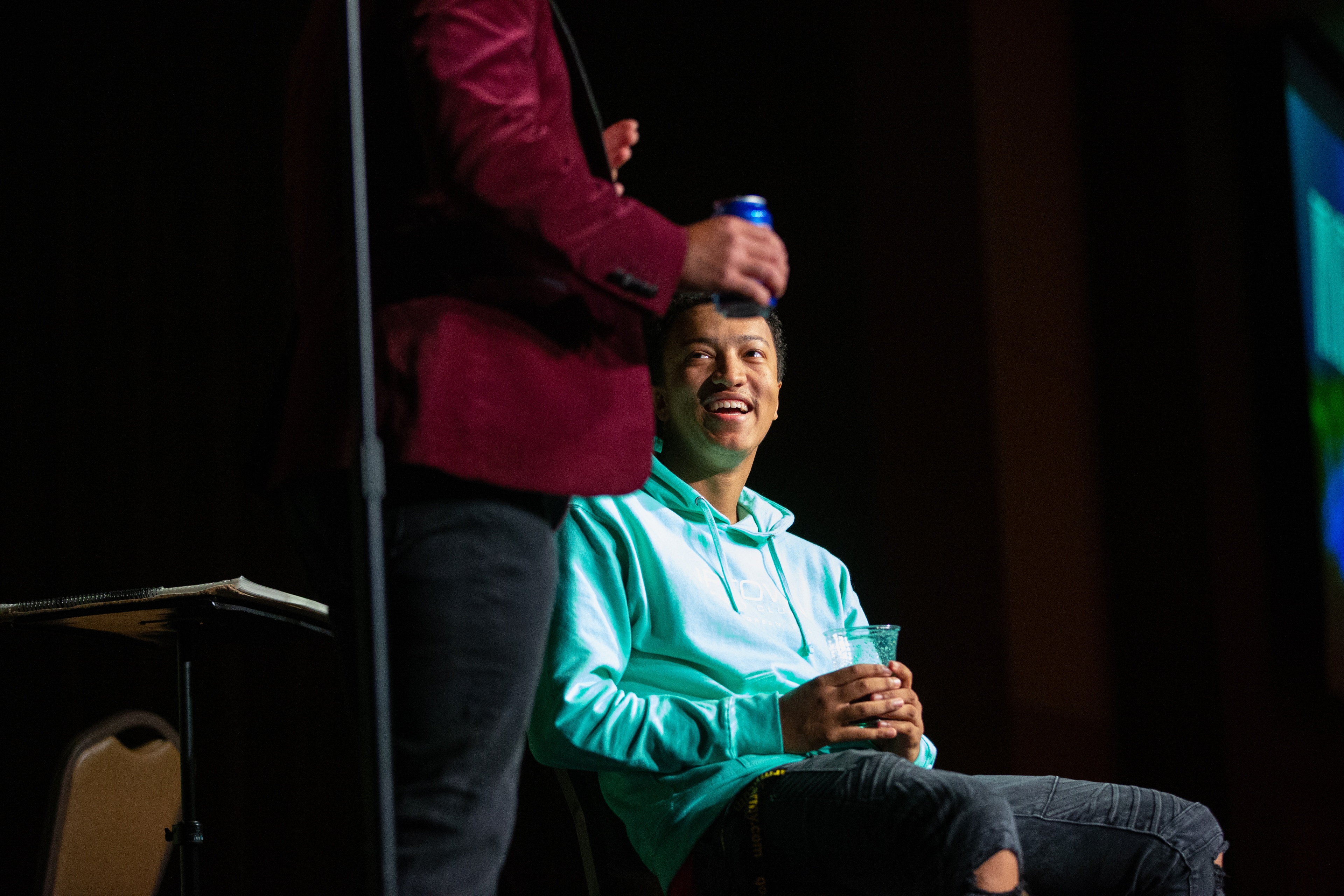 A young man on stage with a magician