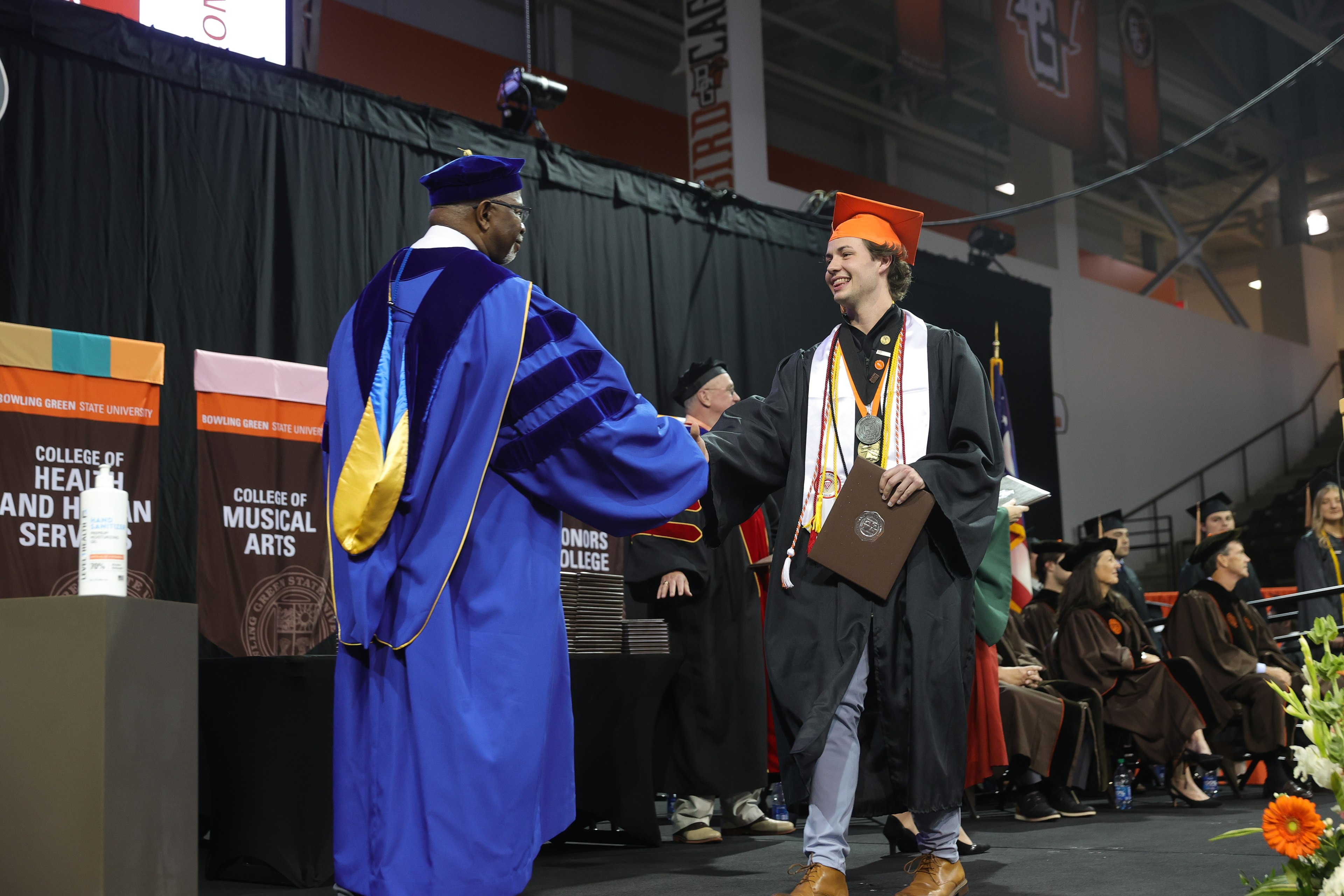 Graduate shakes hands with BGSU Provost and Senior Vice President of Academic and Student Affairs Dr. Joe B. Whitehead Jr.
