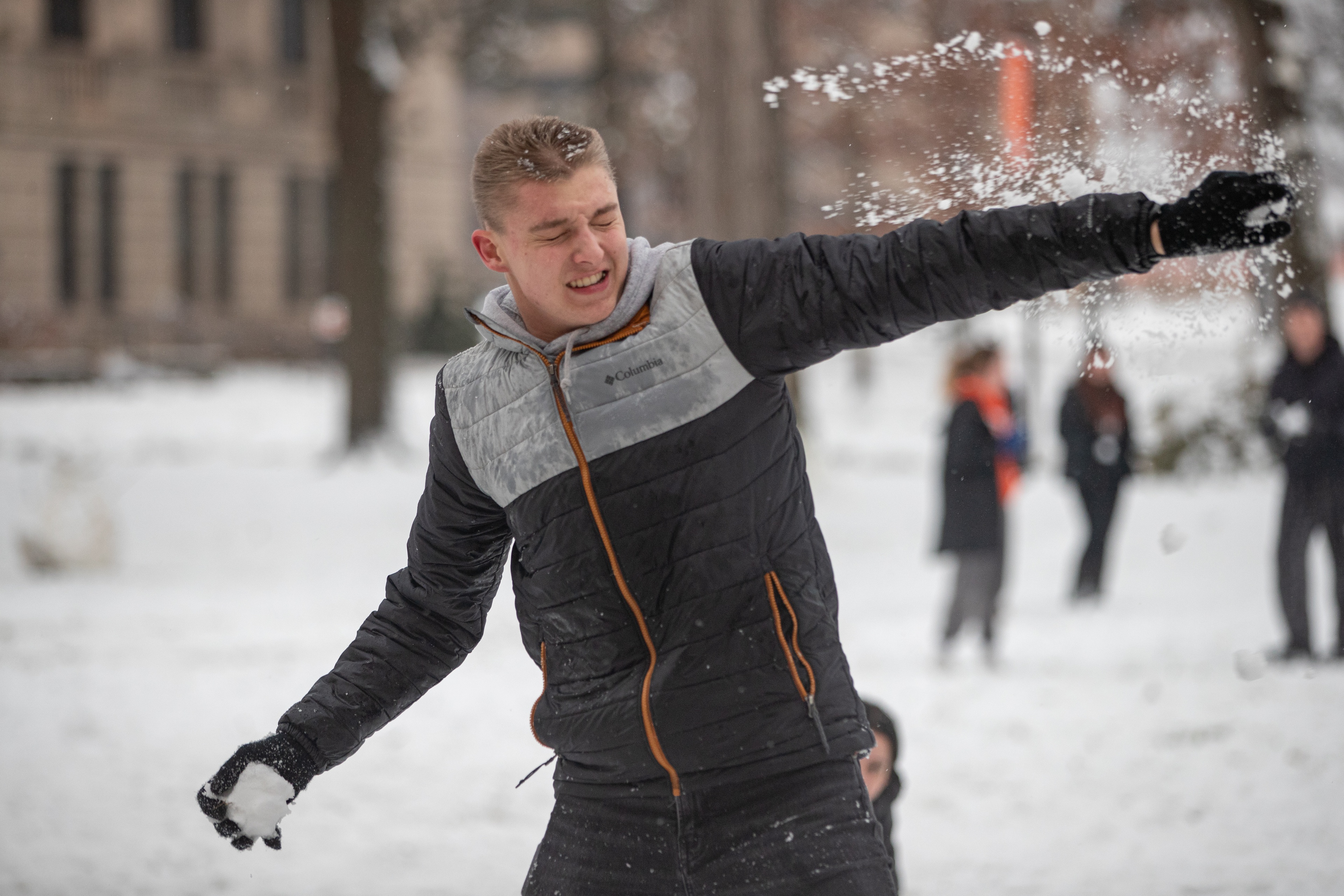 A student ducks from a snowball