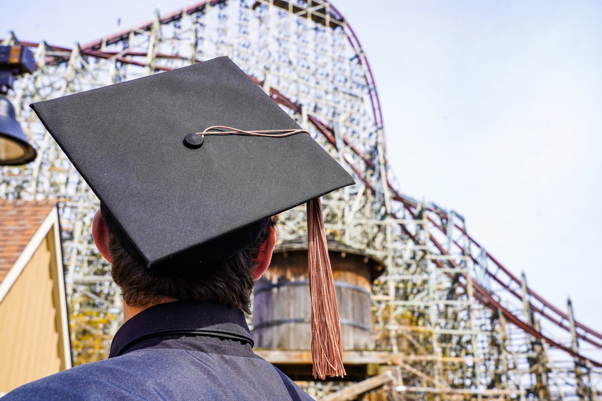 graduate looking at roller coaster