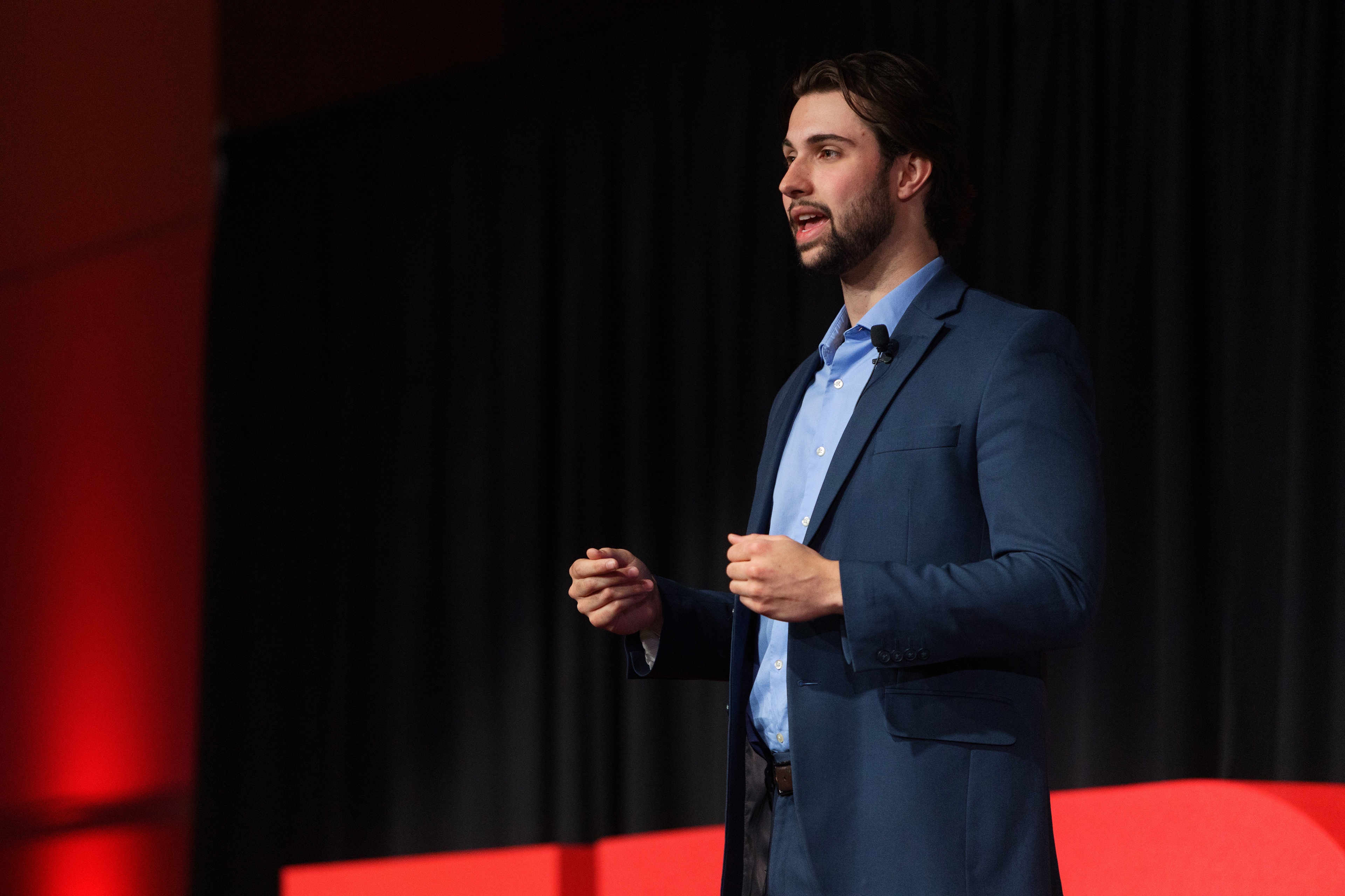 Joshua Auten presenting on stage at TEDxBGSU