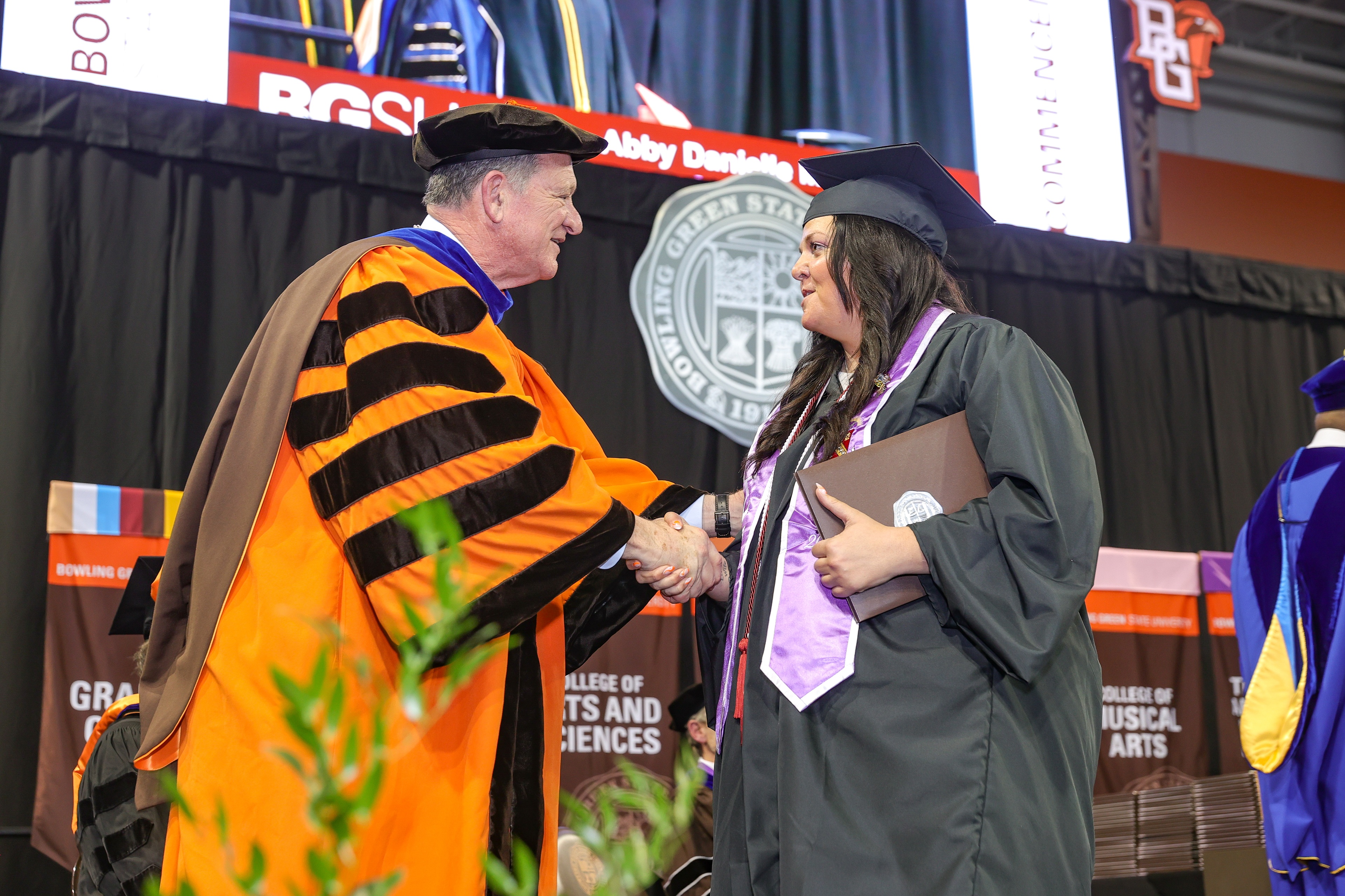 graduate smiling with three family members