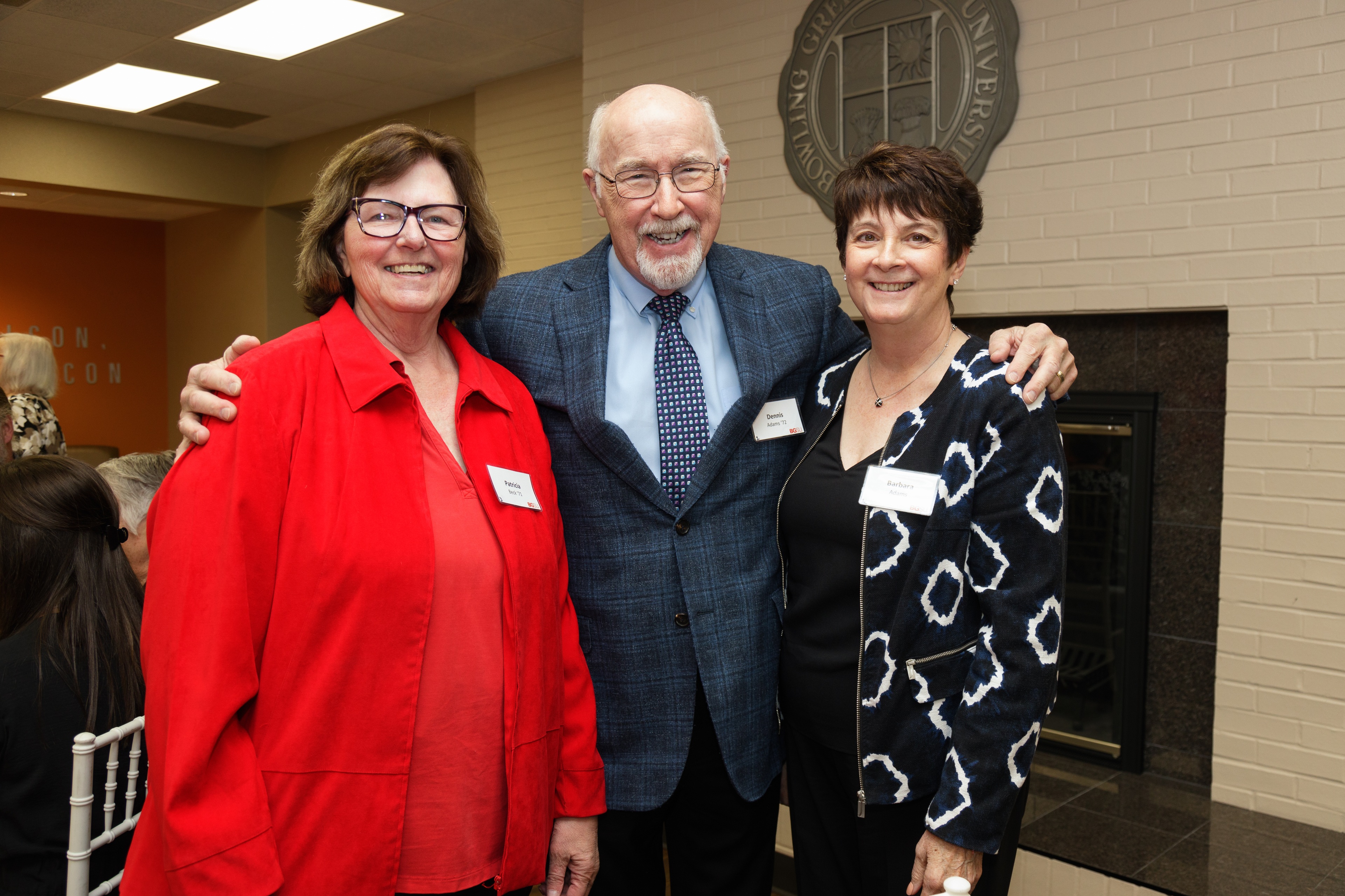 Three BGSU Golden Falcon alumni stand together and pose