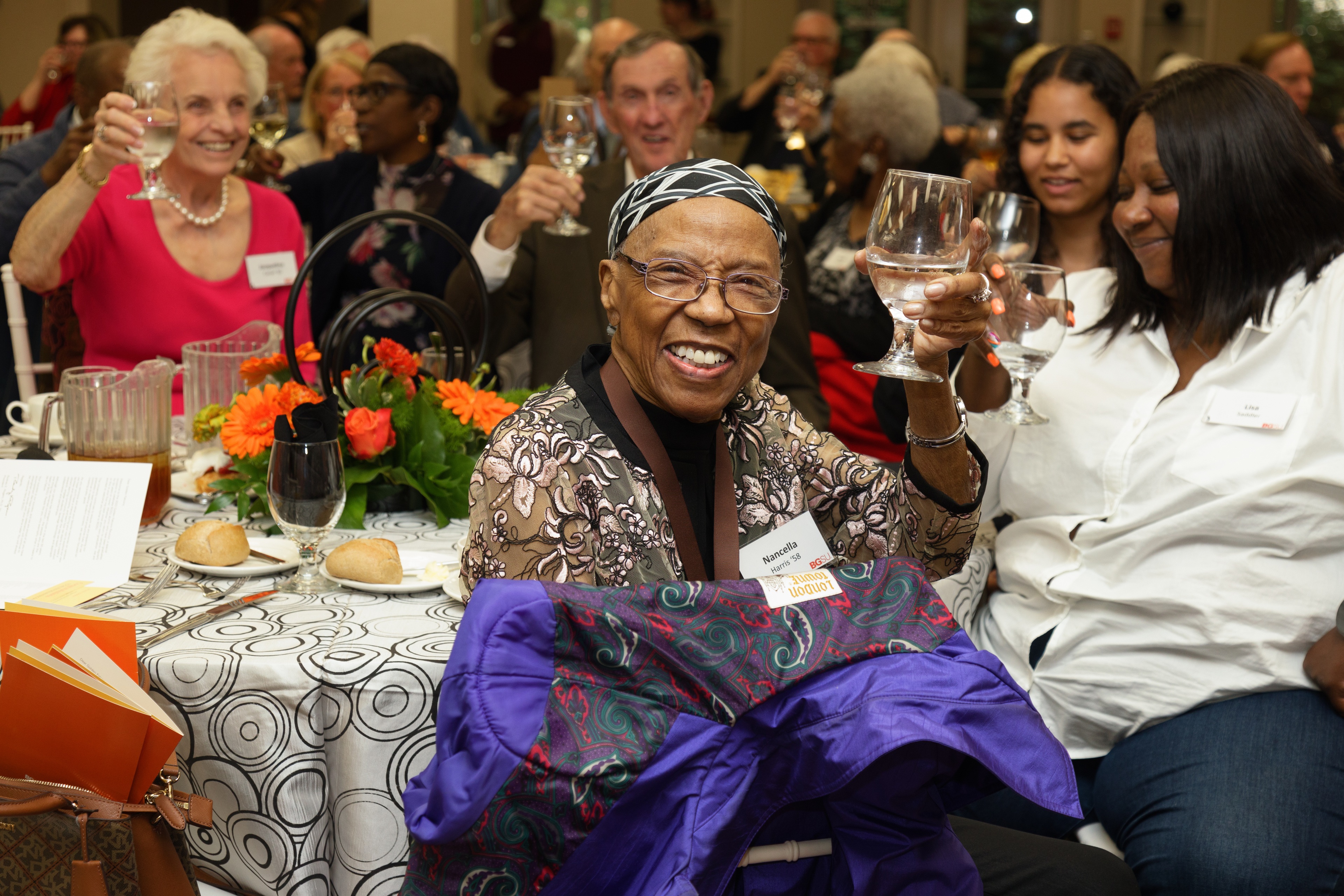 Table of BGSU alumni raise glasses to toast