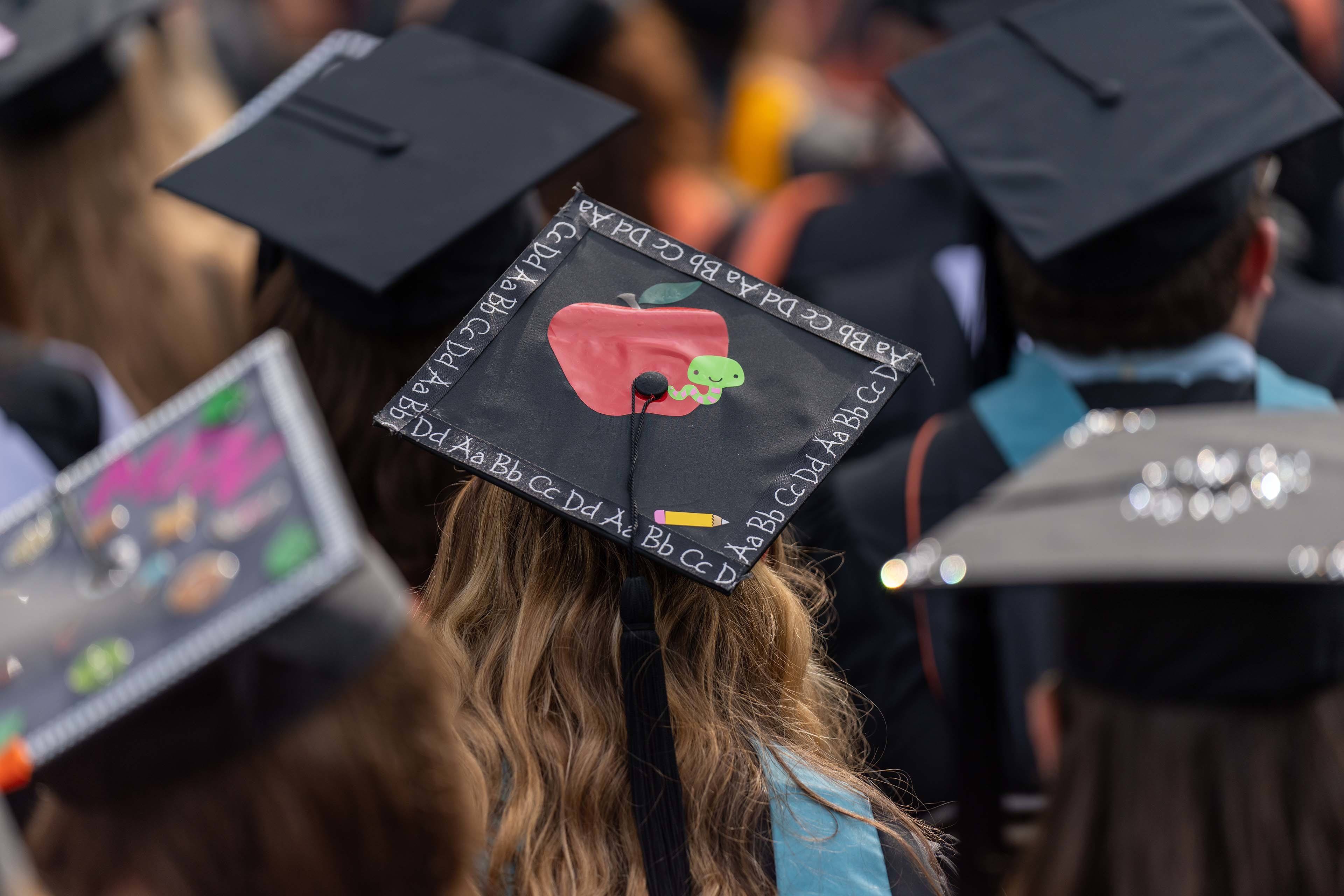 Graduation cap for a future teacher shows the alphabet and an apple
