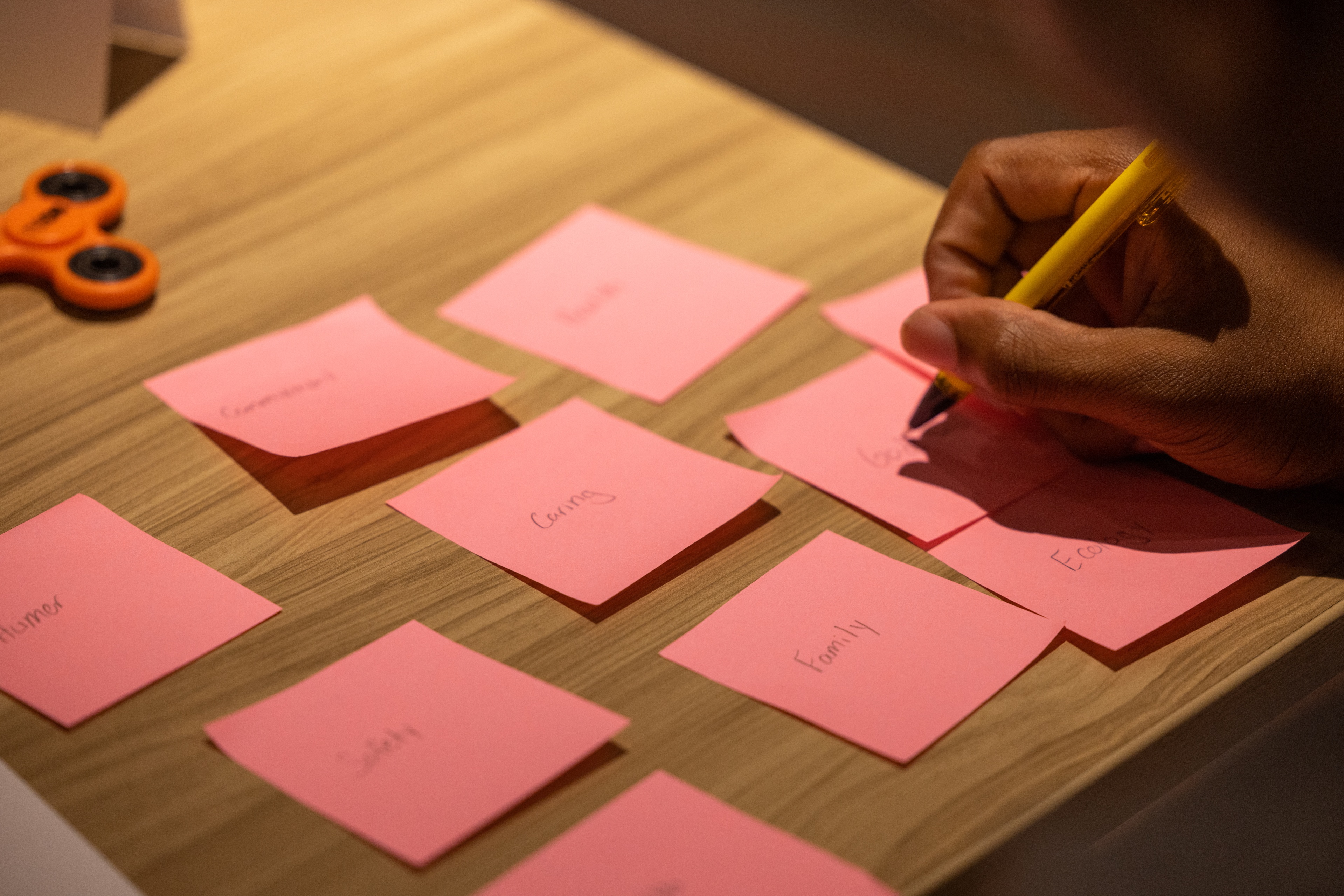 Pinky sticky notes on a desk.