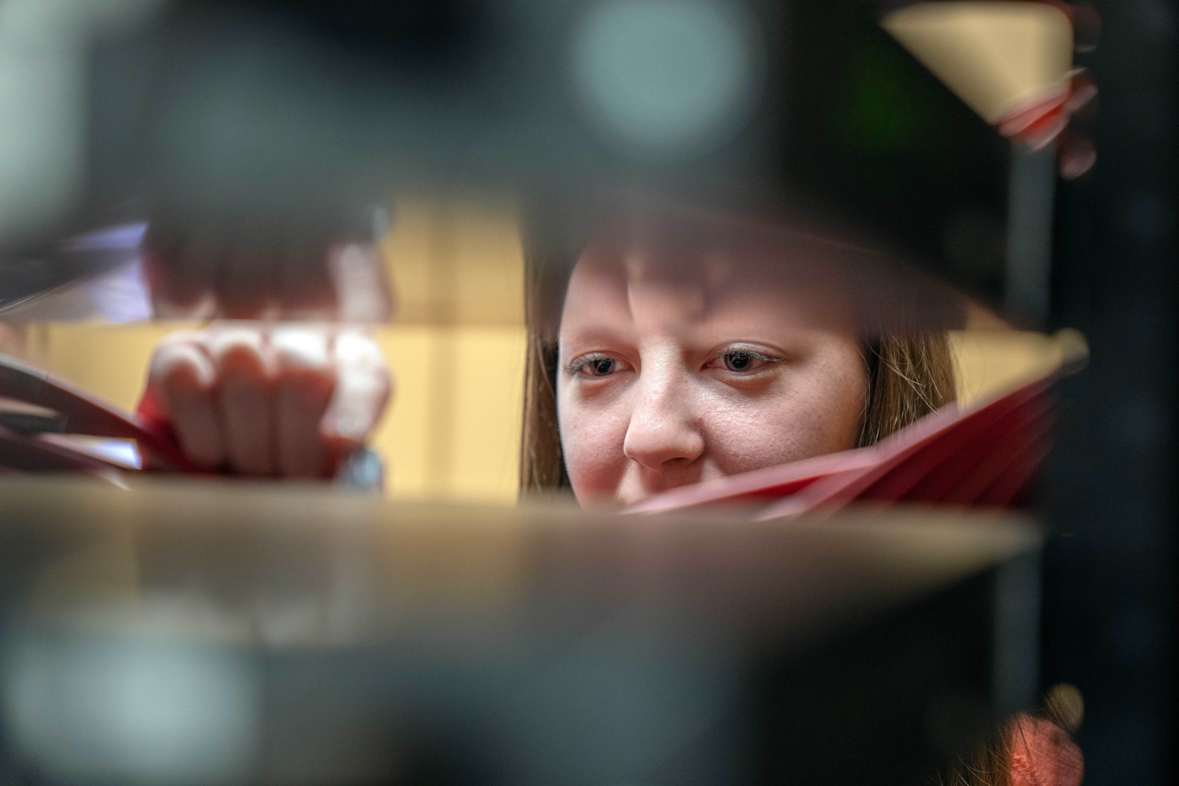 BGSU computer science student peers through computer cables.