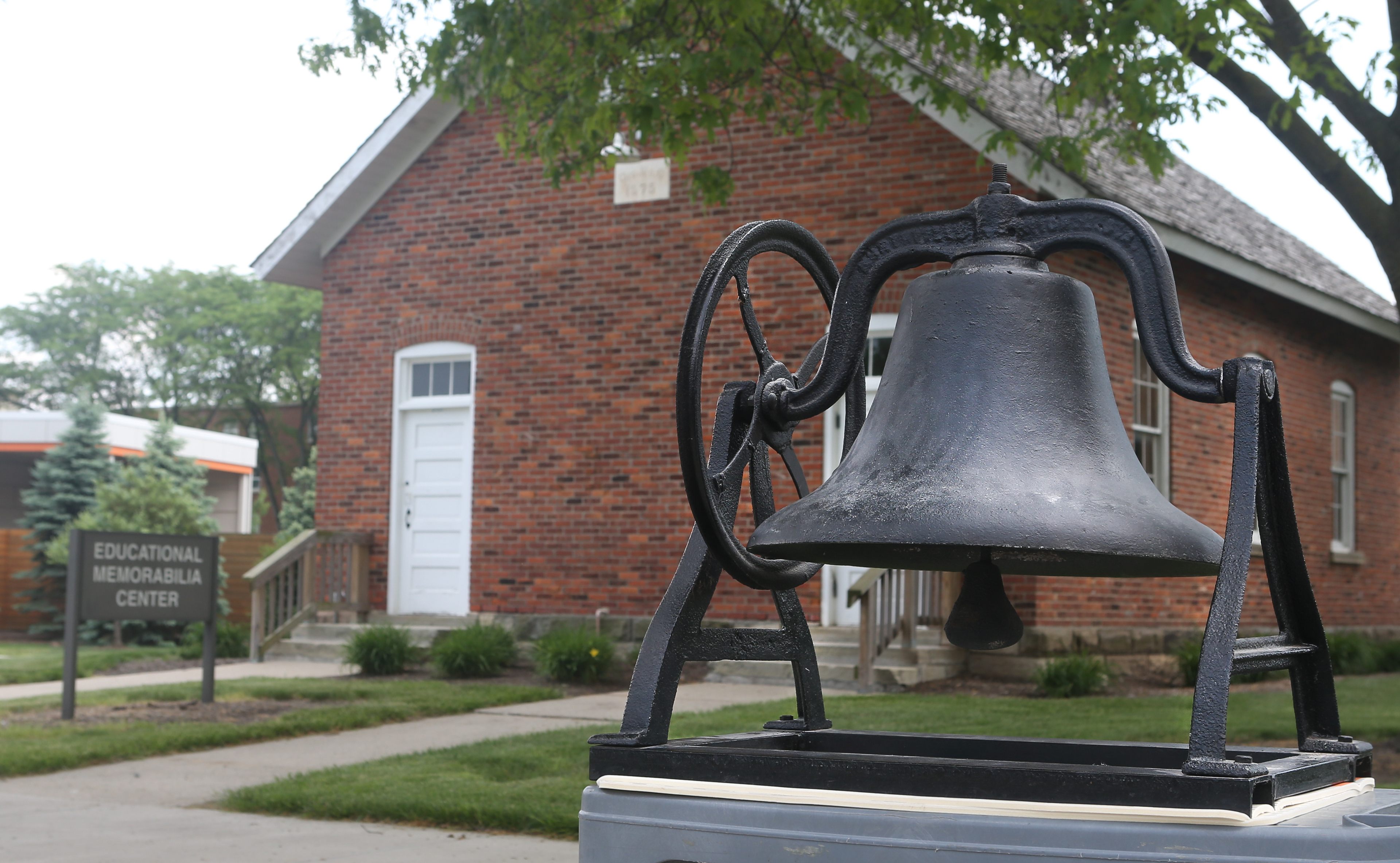 A school bell sits outside the Little Red Schoolhouse on the BGSU campus.