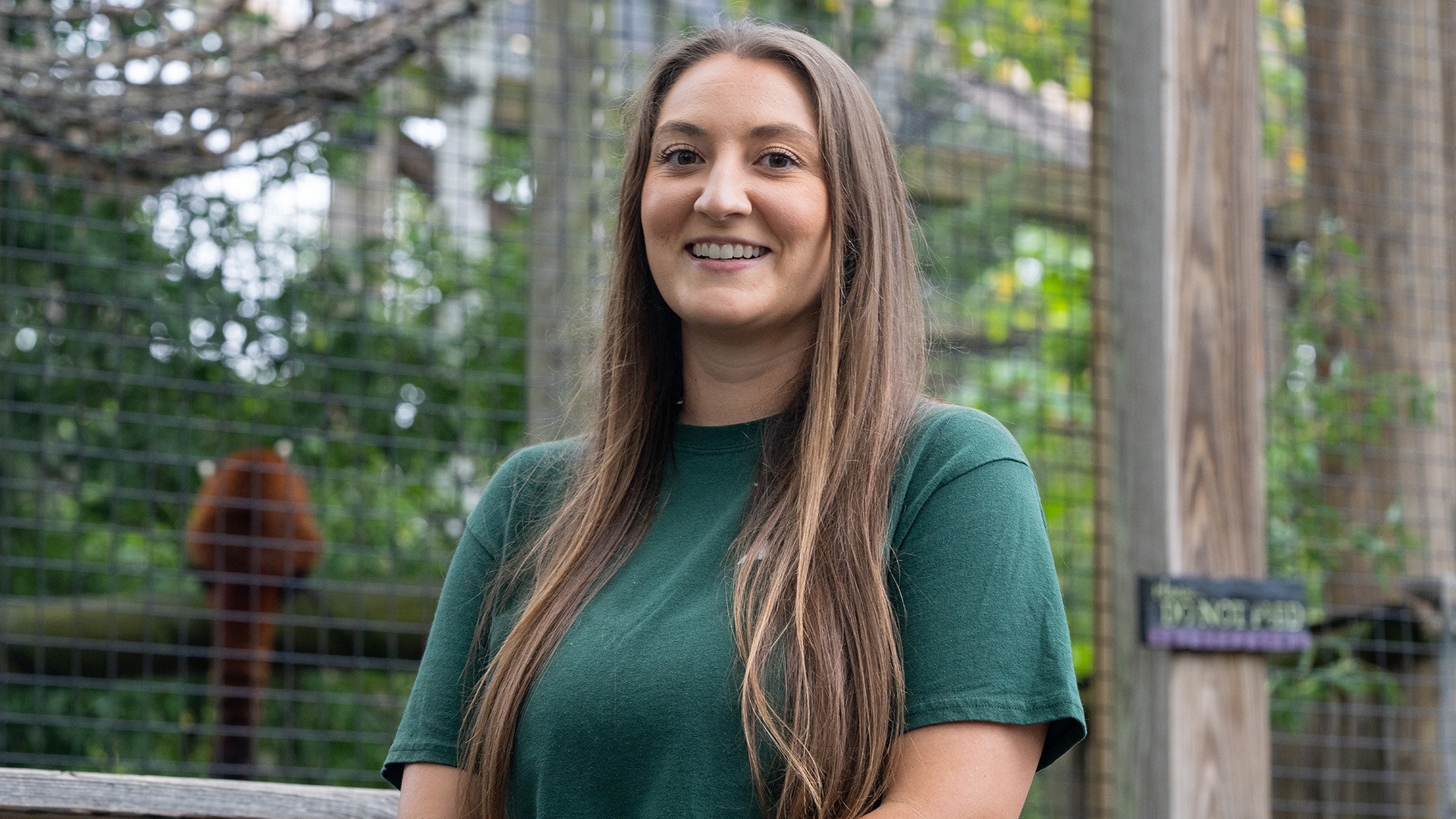 BGSU alumna Molly Beattie stands in front of an animal enclosure at the Toledo Zoo