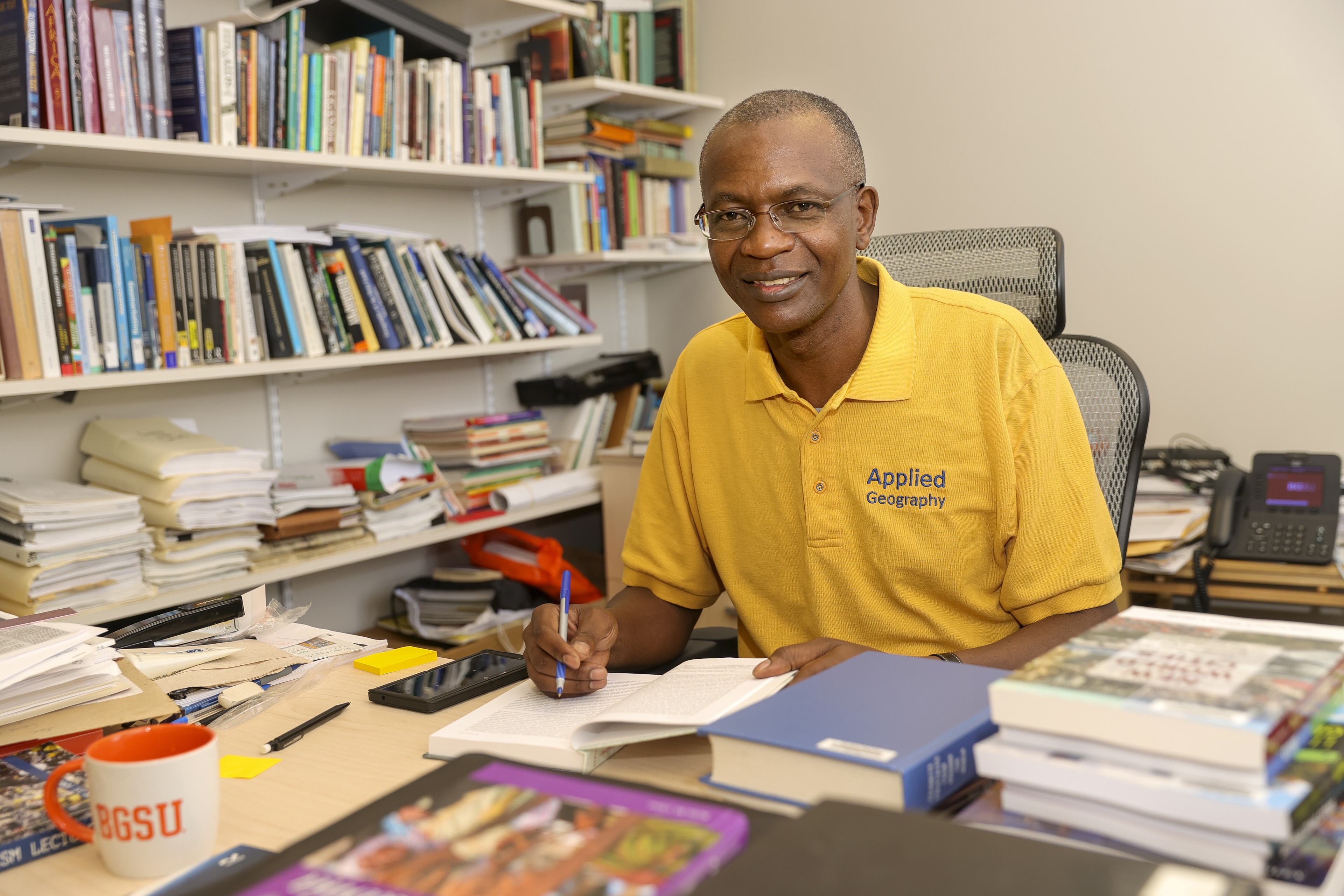 Dr. Kefa Otiso works at his desk.