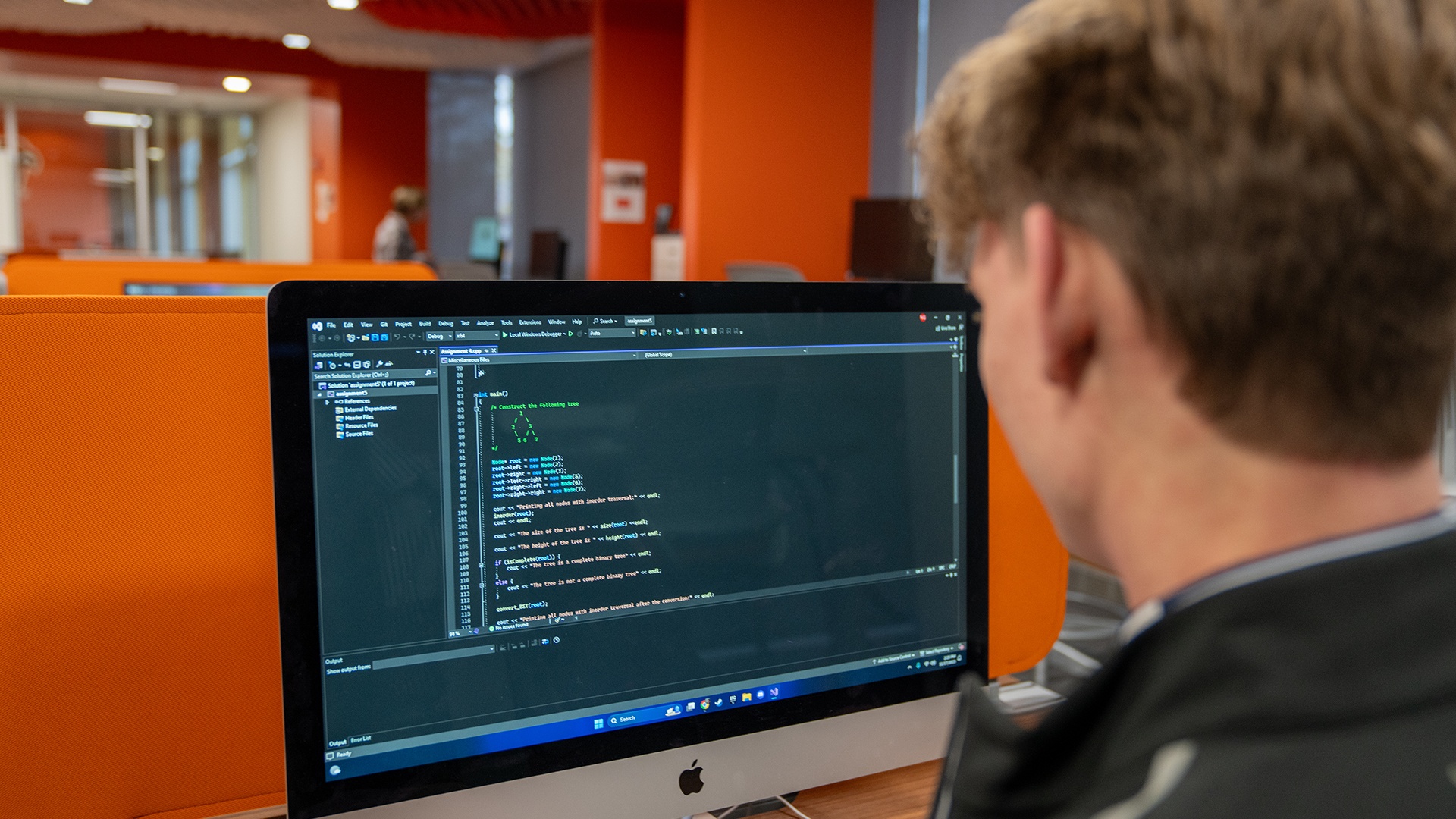 A BGSU student sitting at a desk looking at a computer