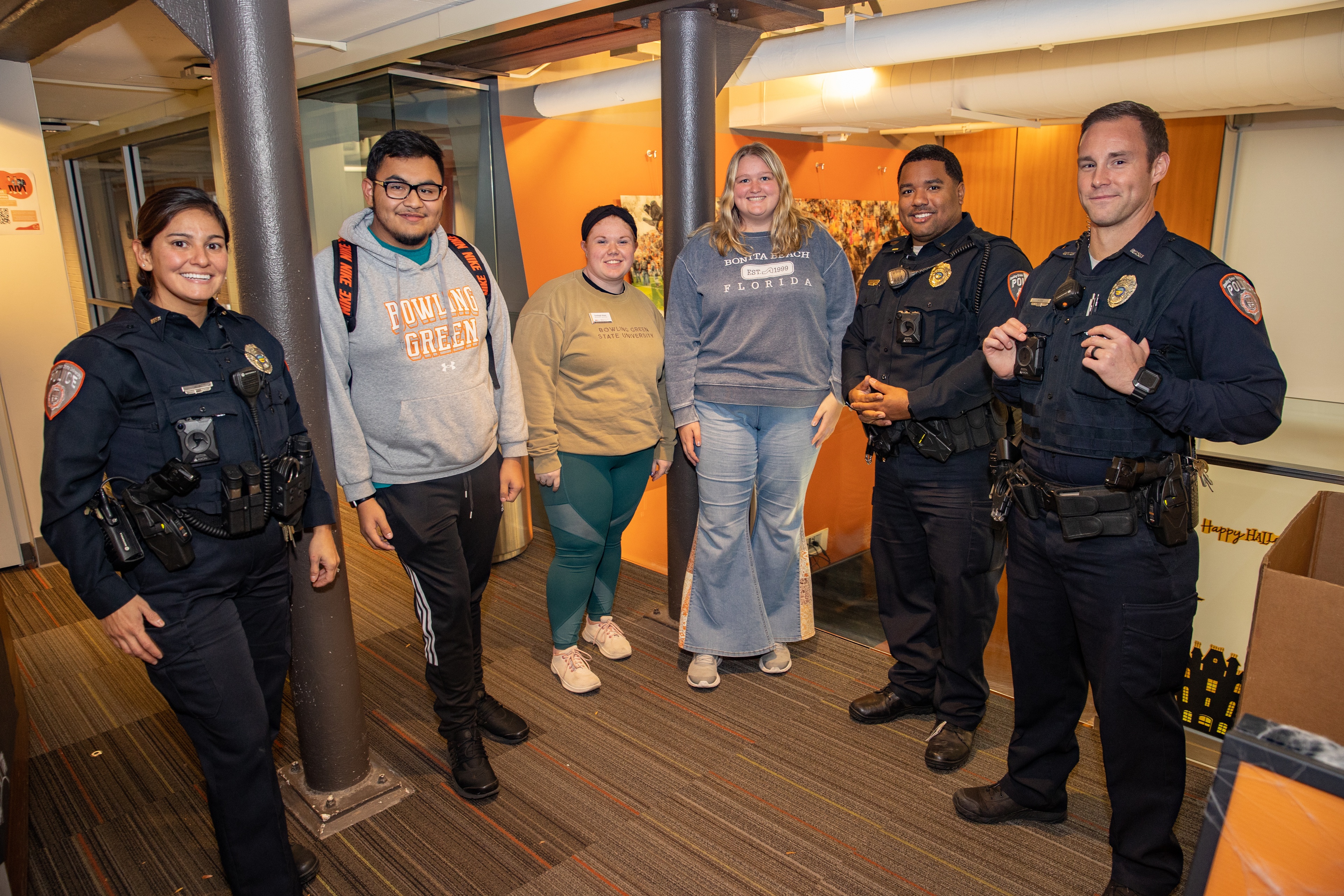 BGSU Police officers pose for a photo with students inside a residence hall.