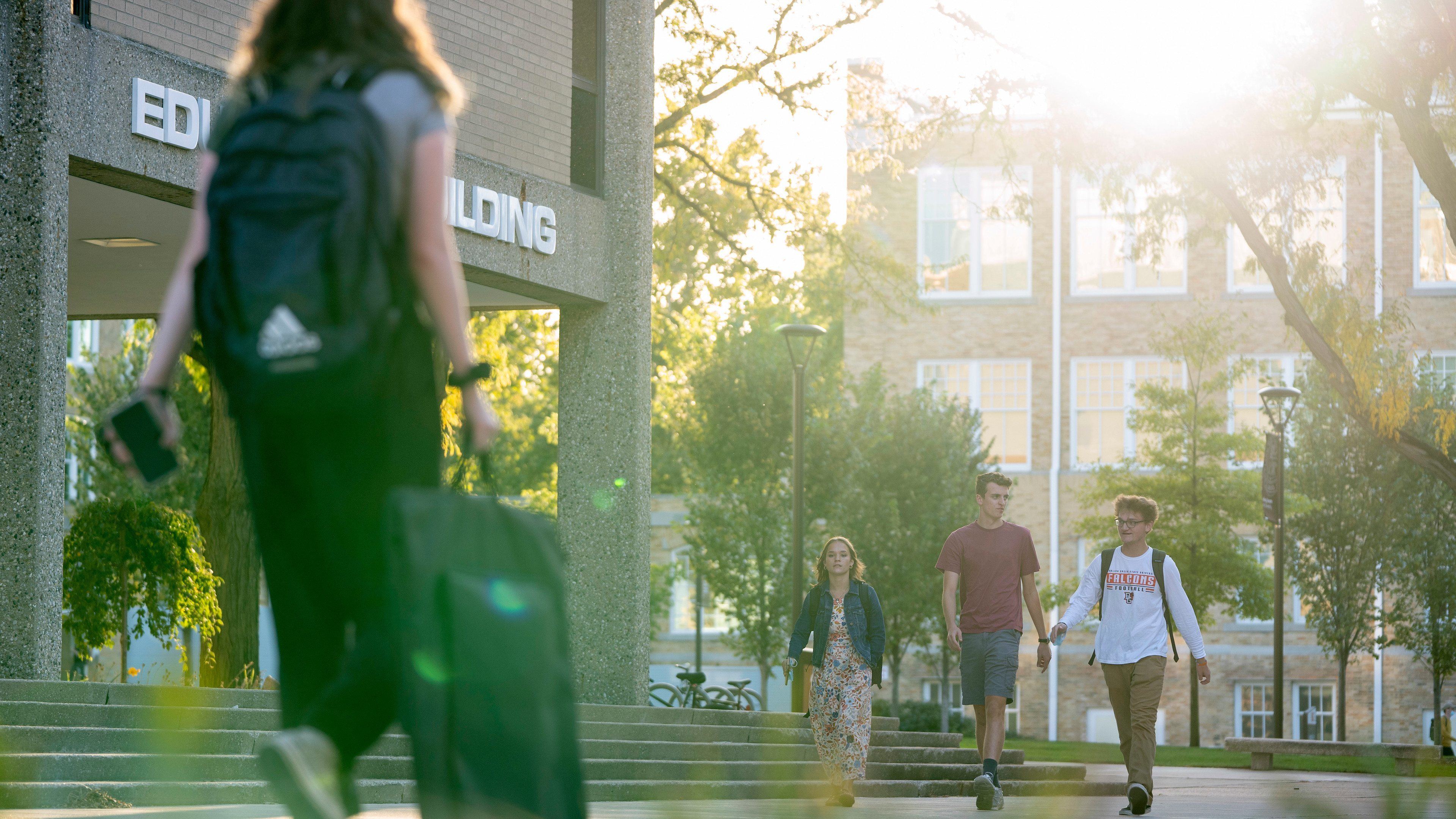 Four students walk past the Education Building on the BGSU campus