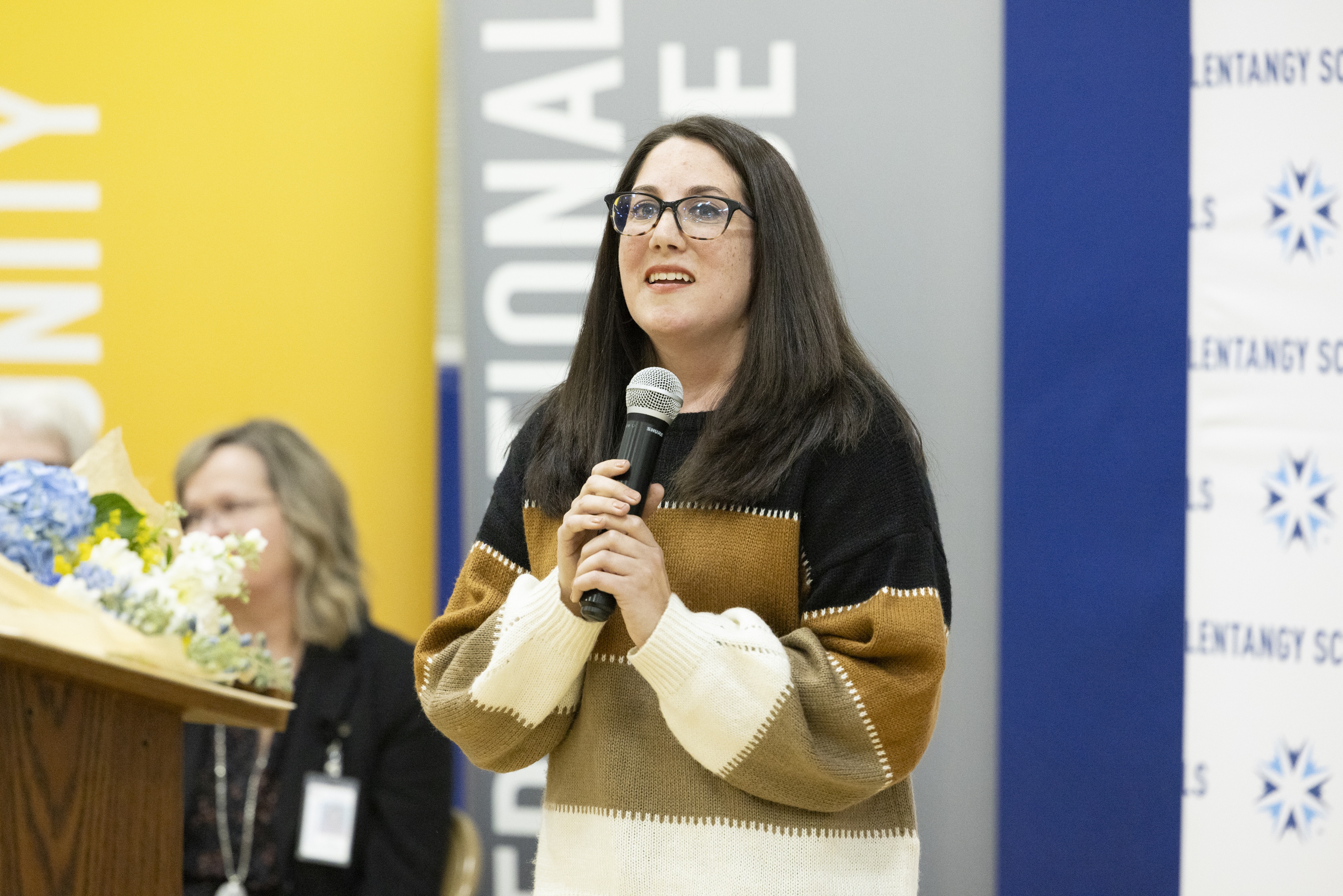 A woman holds a microphone. 